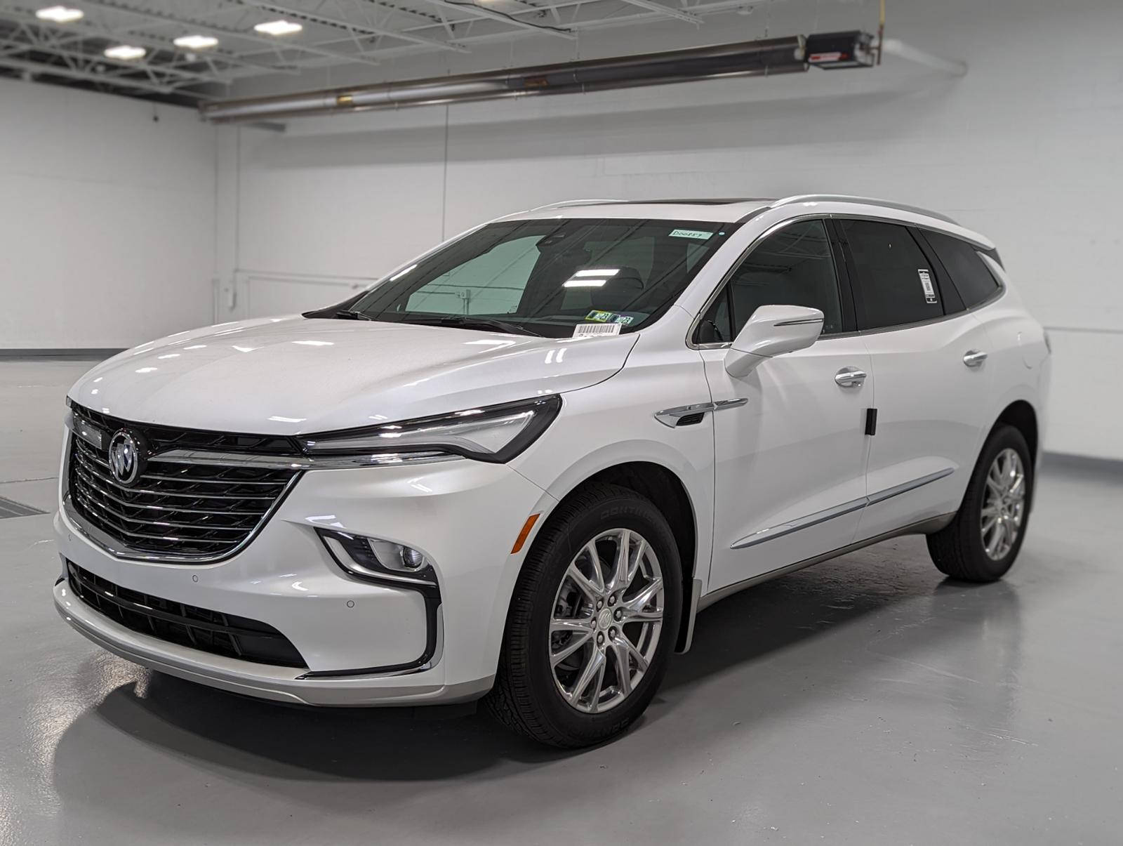 白色Buick Enclave SUV在明亮的室內展廳中，拋光地板和天花板燈光。