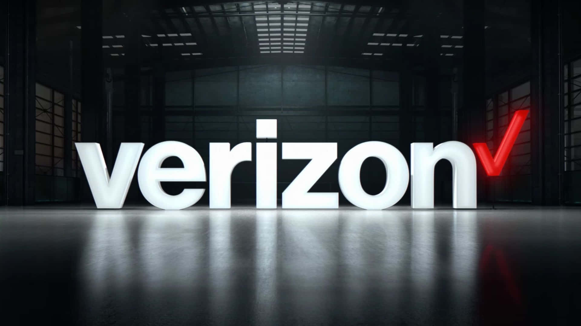黑暗倉庫中發光的Verizon標誌，反射地板