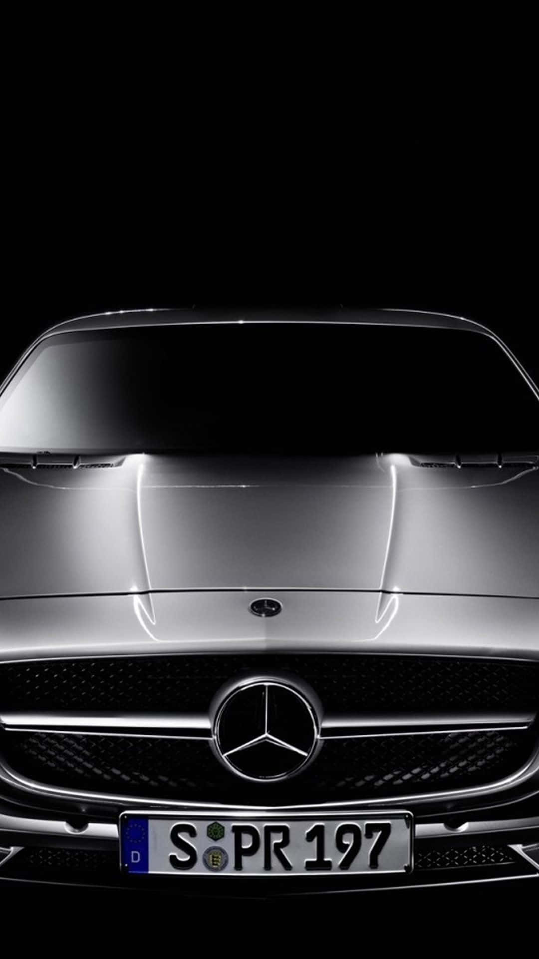 帶有標誌和車牌的銀色 Mercedes-Benz 汽車前格柵特寫。