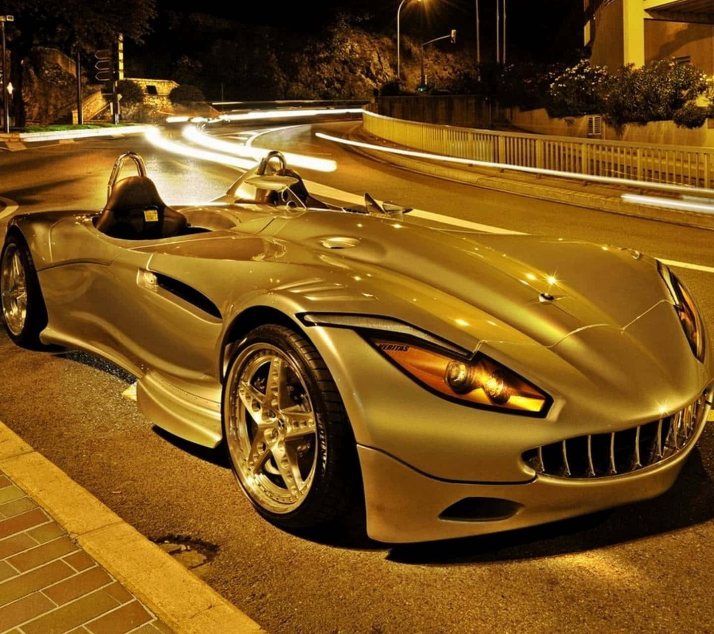 金色跑車夜間停泊在濕滑街道上，帶有光軌。