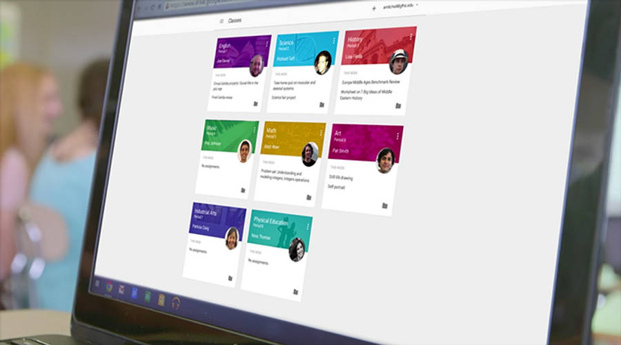 展示 Google Classroom 界面的筆記型電腦 壁紙 — 在教室環境中，手提電腦屏幕顯示色彩繽紛的學生項目卡片，附有照片和標題。