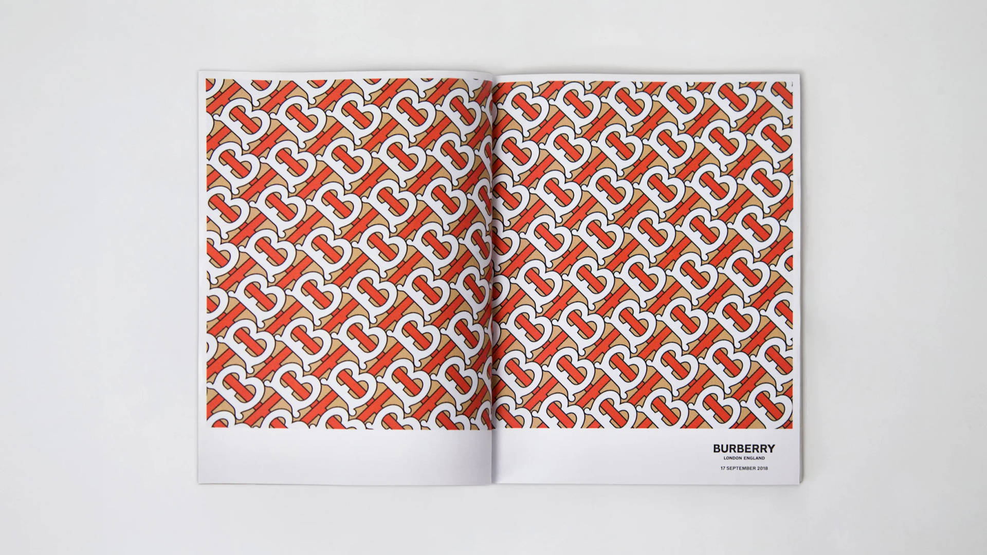 打開的雜誌展示 Burberry 標誌圖案（紅、白、米色）