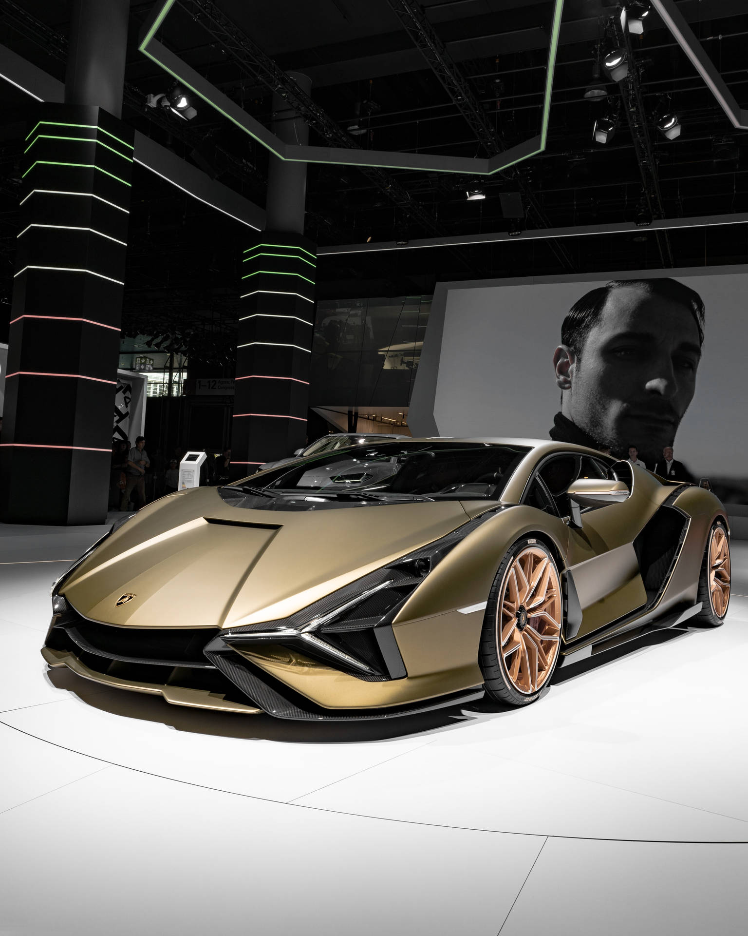 金色林寶堅尼跑車在車展上展出，配有霓虹燈光和肖像背景。