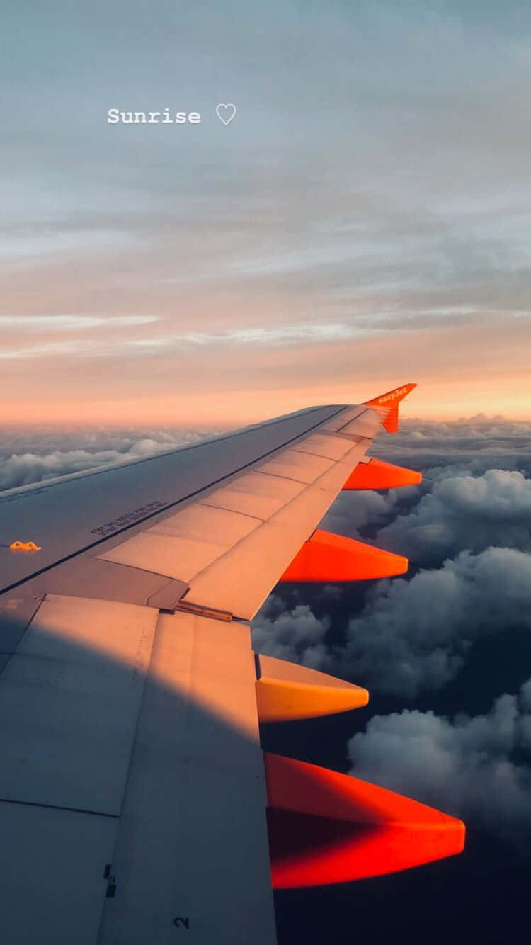 日出時的飛機機翼，雲層上方有橙色光芒