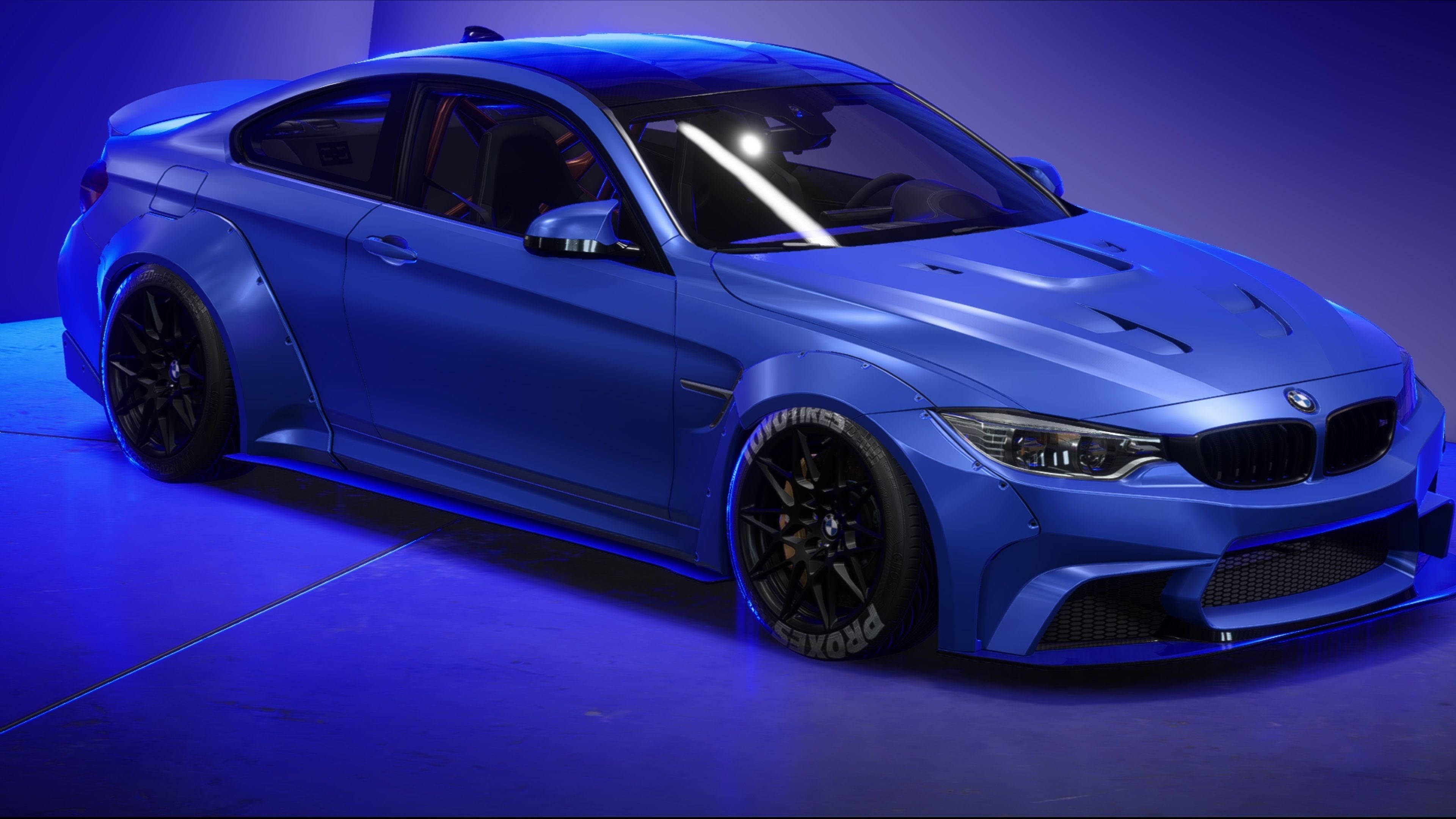 展覽中的美麗藍色寶馬 壁紙 — 一輛啞光藍色BMW M4雙門轎跑車，配備黑色輪圈和侵略性造型，在戲劇性的藍色工作室燈光下閃耀。