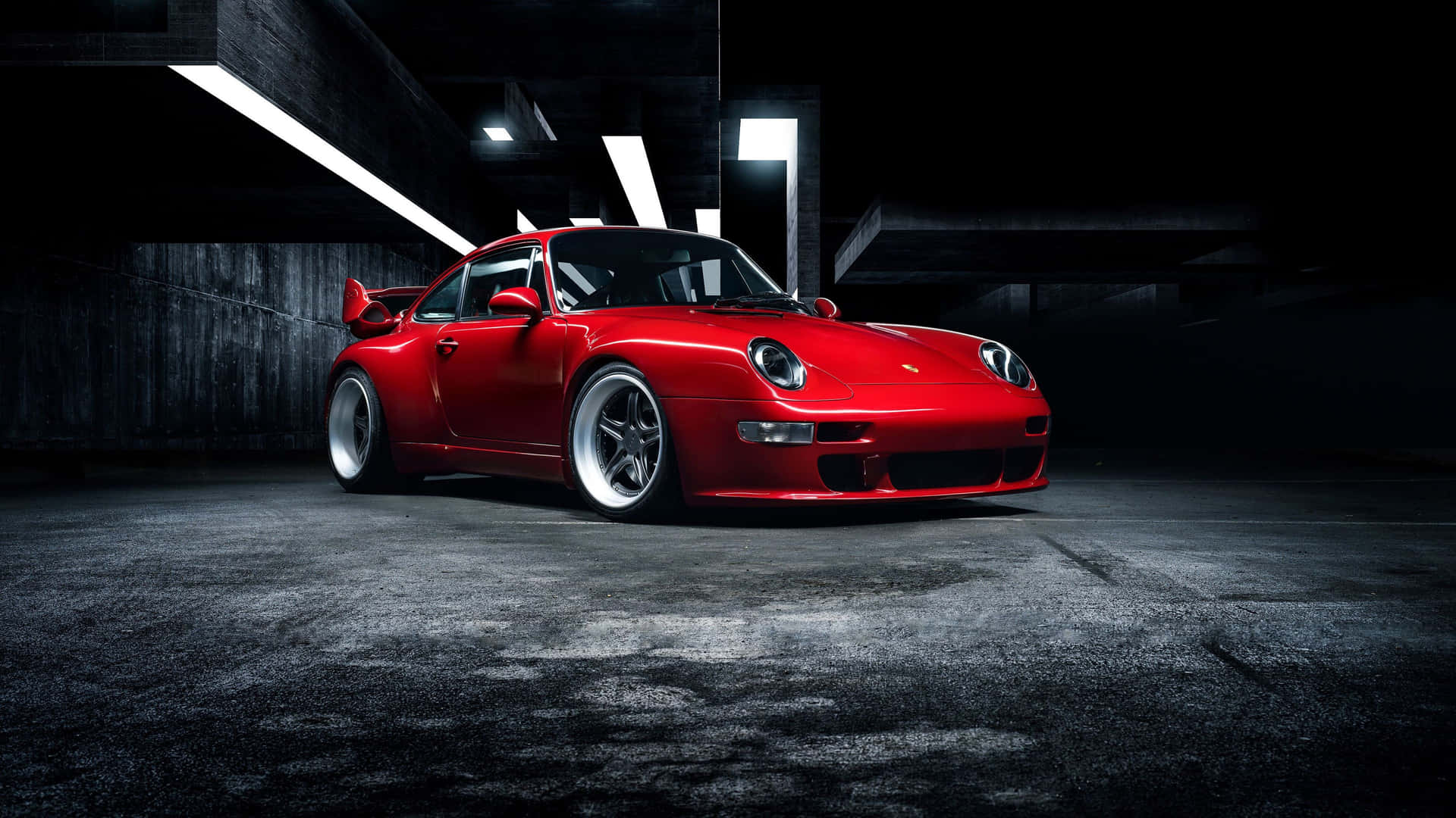 紅色保時捷911 Turbo停在燈光昏暗的地下停車場，帶有戲劇性照明。