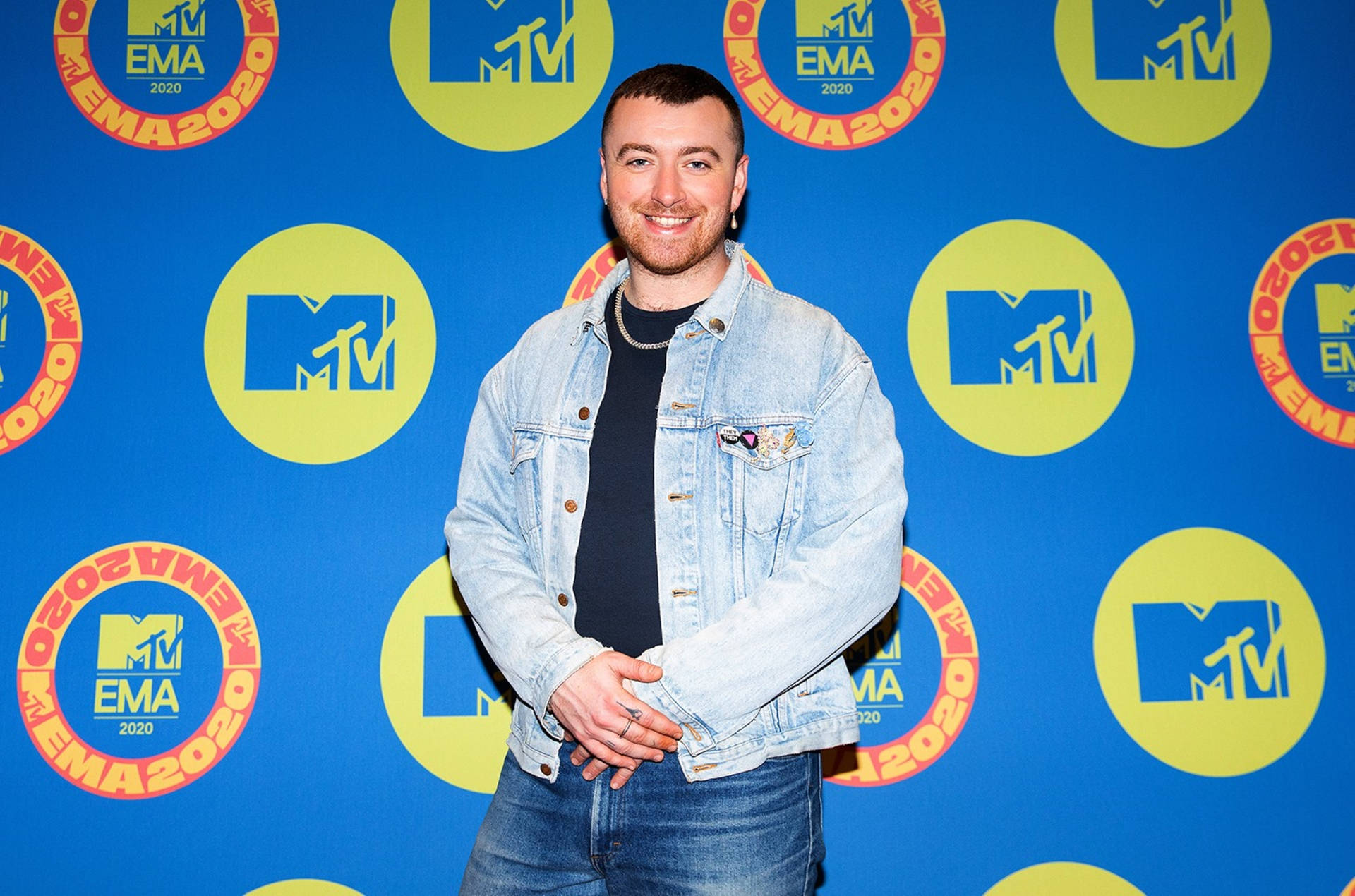 身穿牛仔外套的男子在MTV EMA 2020活動背景前微笑。