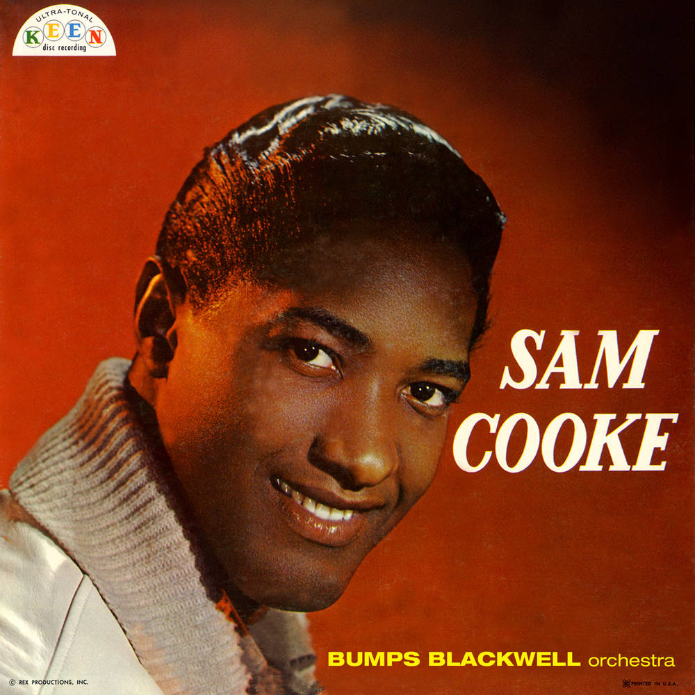 Sam Cooke 在工作室肖像中微笑，背景為橙色並帶有文字。