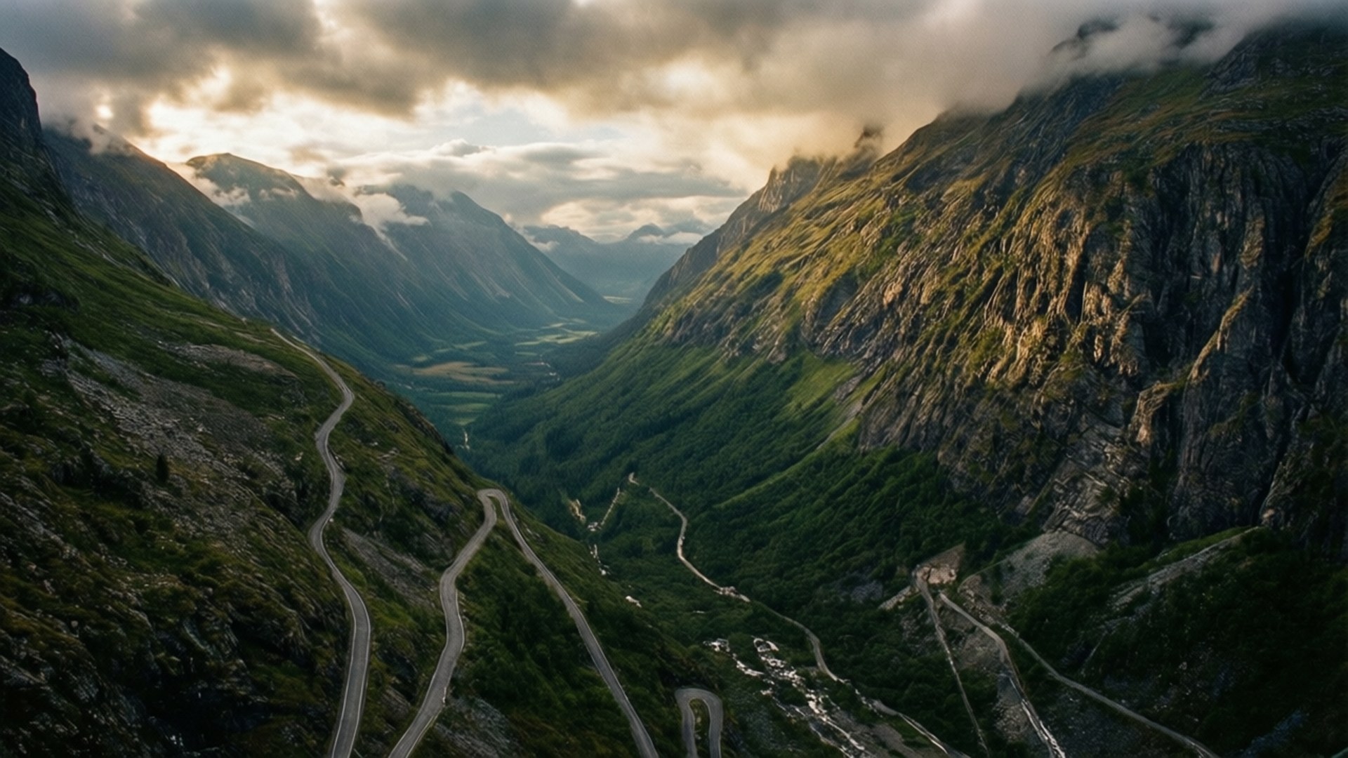 蜿蜒的道路穿過山谷，有綠色山坡和陰天