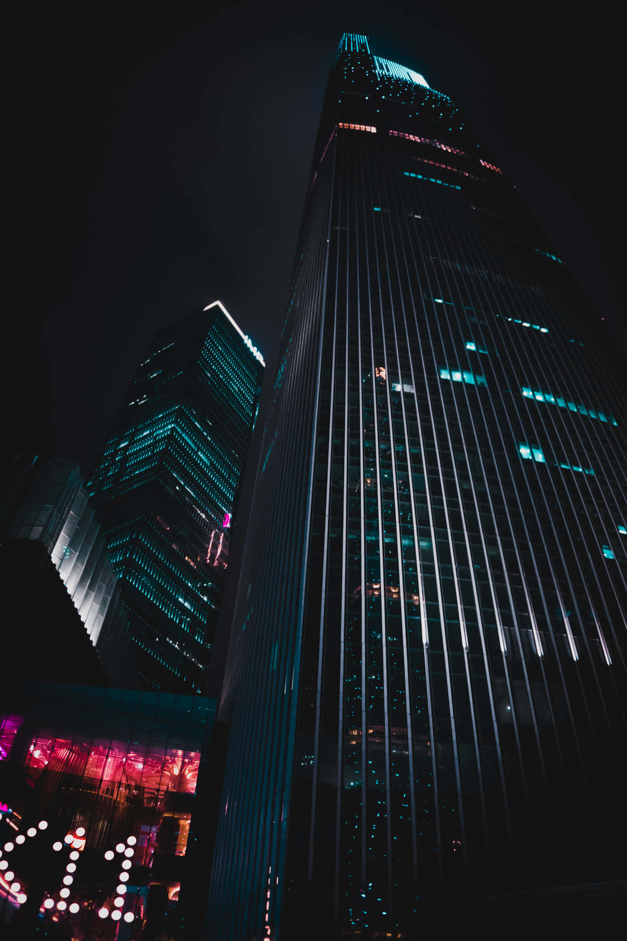夜晚的城市景觀，有燈火通明的摩天大樓和霓虹燈。