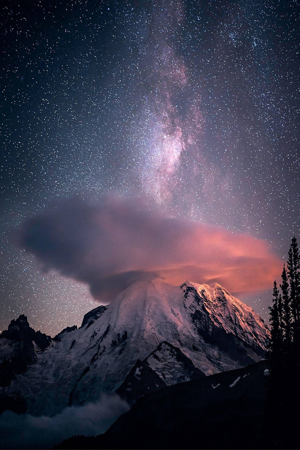 星空下的雪山，銀河和粉紅色的雲。