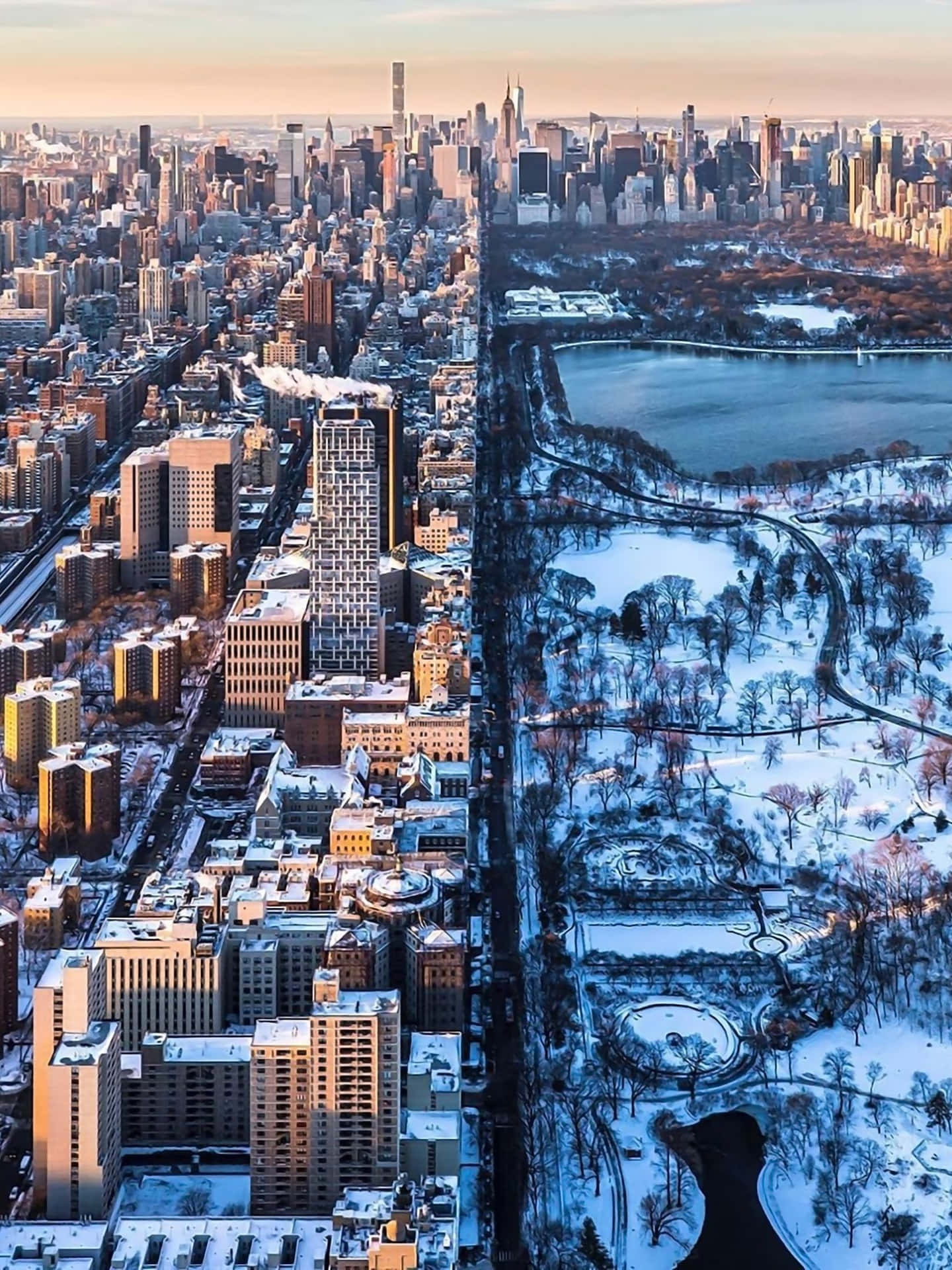 雪景城市風光，中央公園和日落時分的摩天大樓。