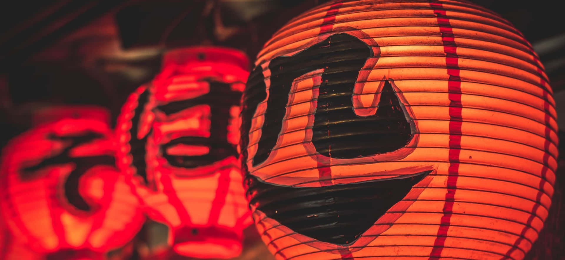 發光紅色日本燈籠，帶有黑色漢字，在節日夜晚環境中。