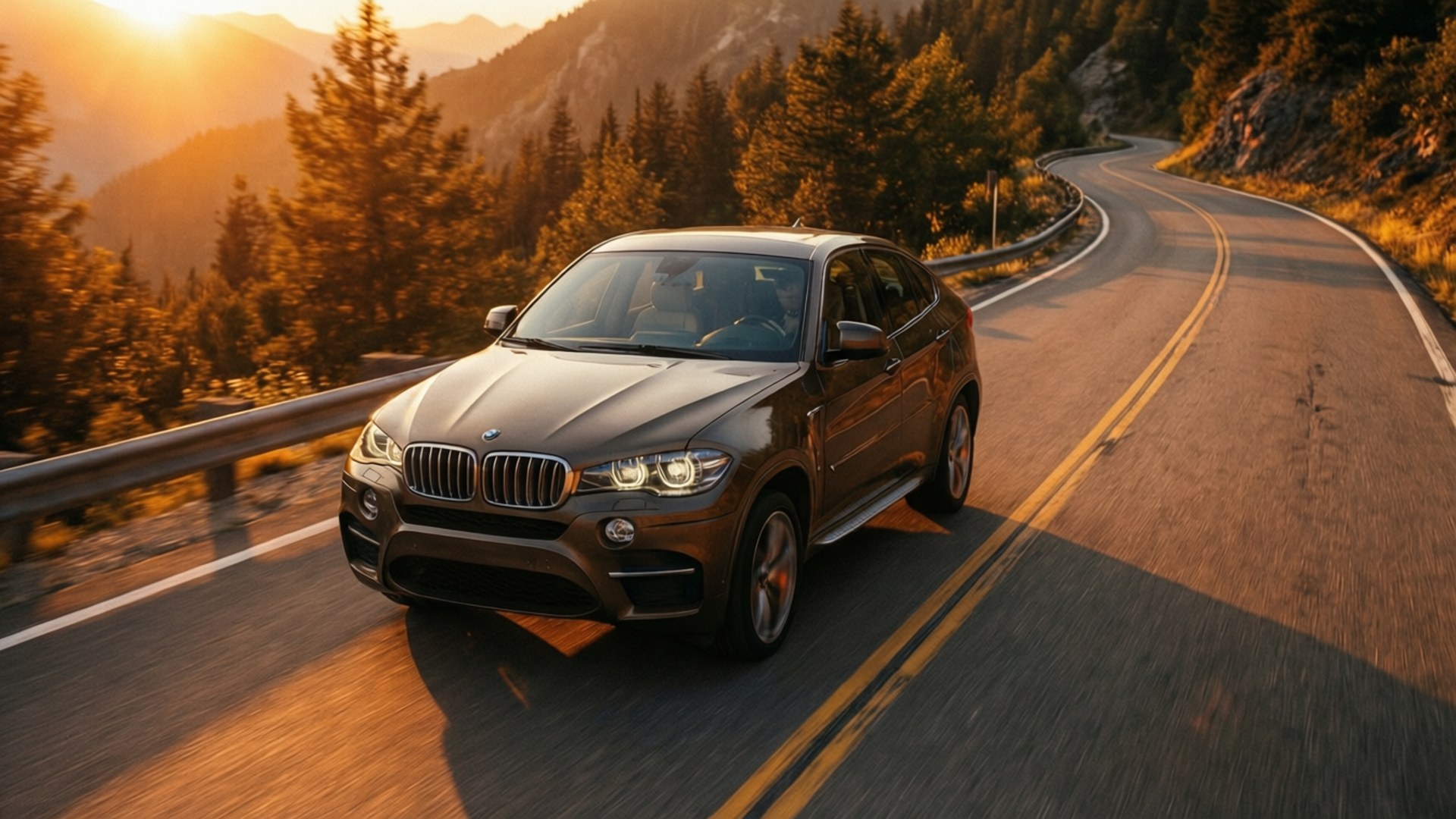 青銅色BMW X6在金色日落時分行駛在山路上。