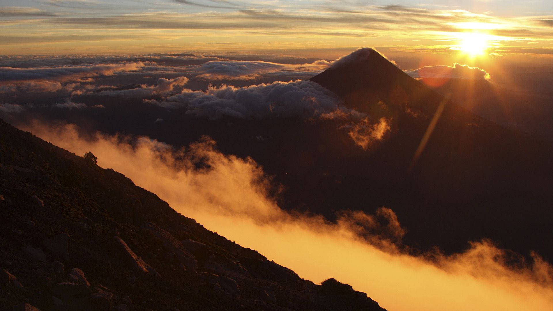 日出時的山峰，下方雲層在金色光芒中閃耀。