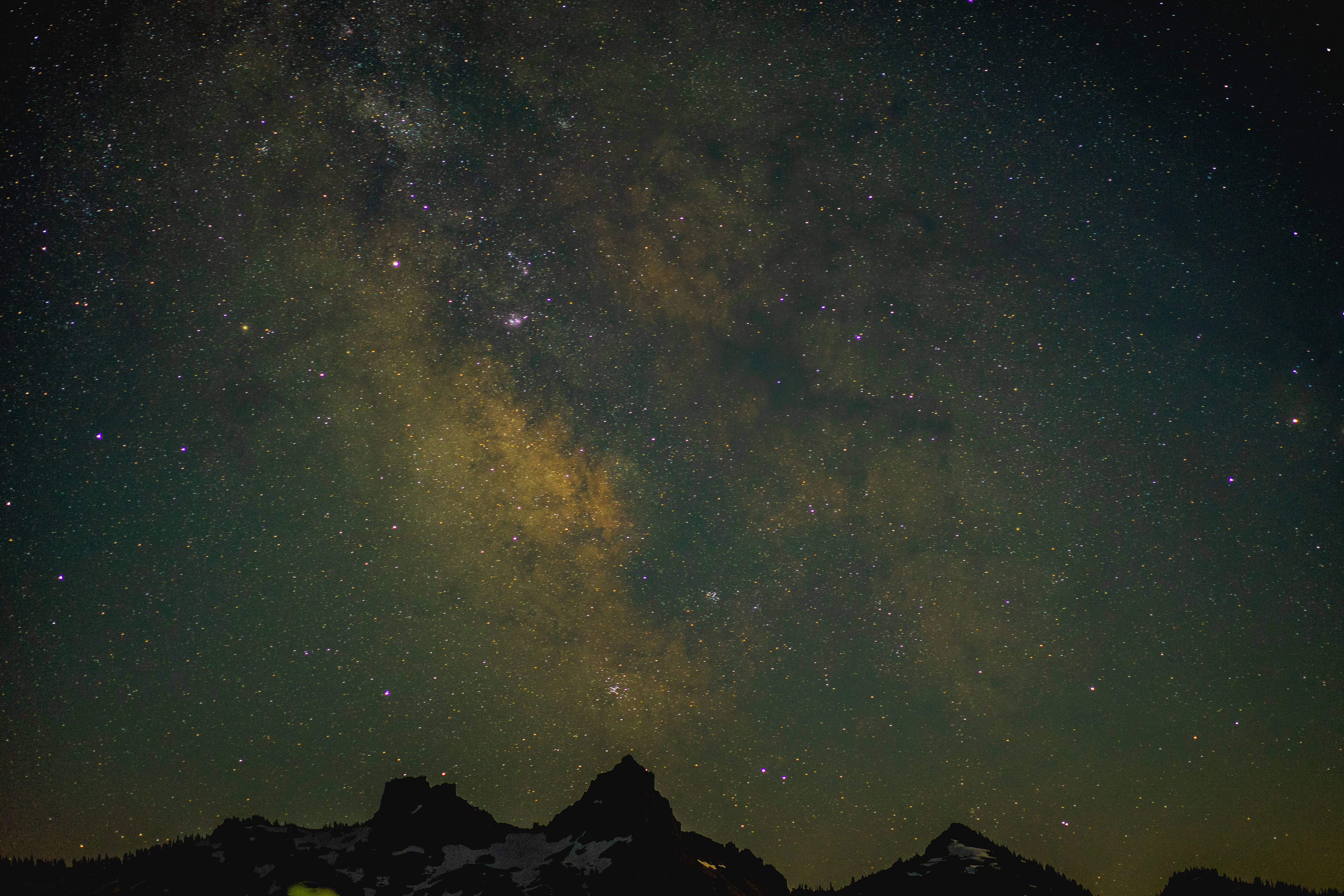 山頂上的翠綠夜空 壁紙 — 令人嘆為觀止的夜空，佈滿無數星星，閃耀的銀河在崎嶇的山峰上彎曲。