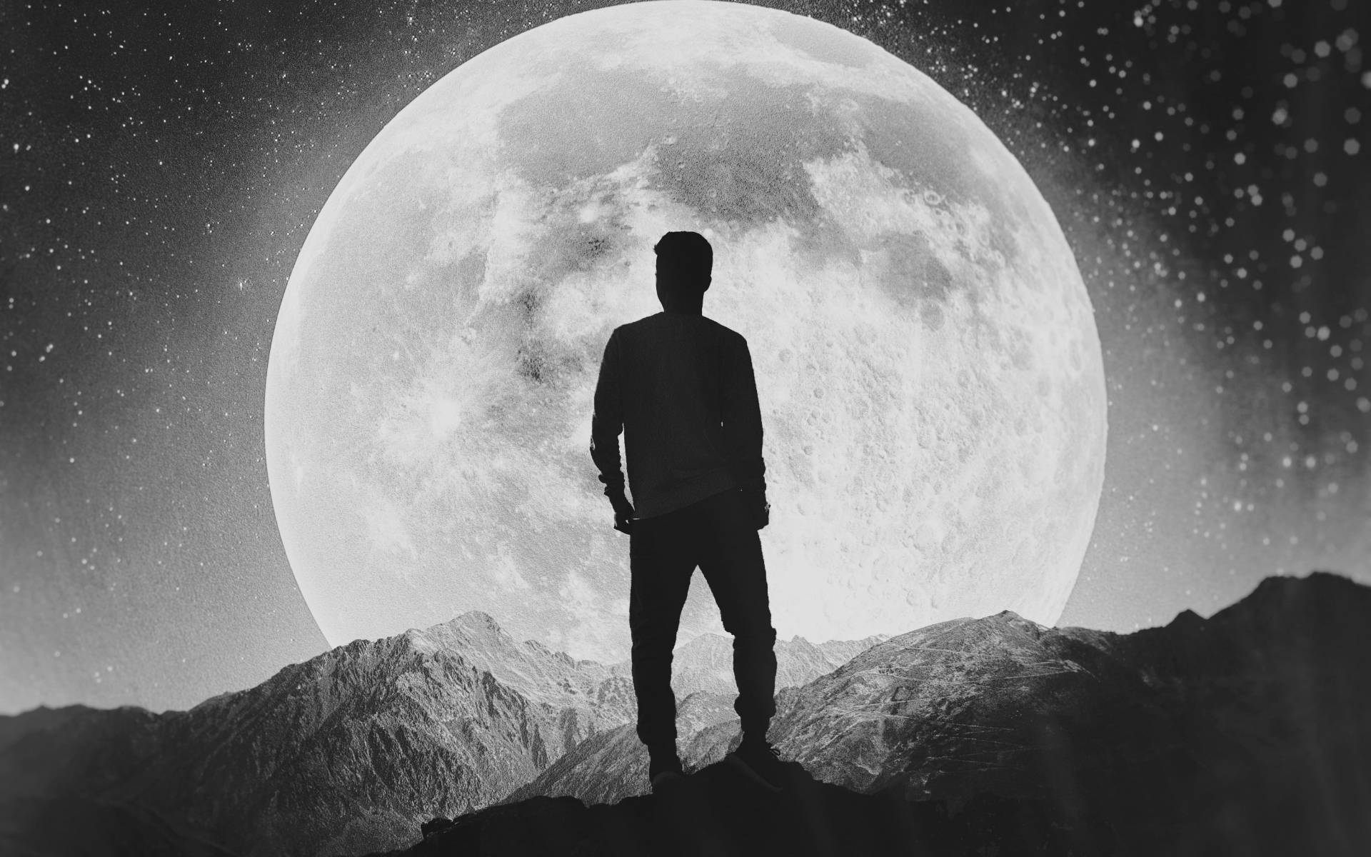 山頂孤影 壁紙 — 一個孤獨的身影站在山脊上，剪影映襯著巨大而細節豐富的月亮和繁星點點的夜空。