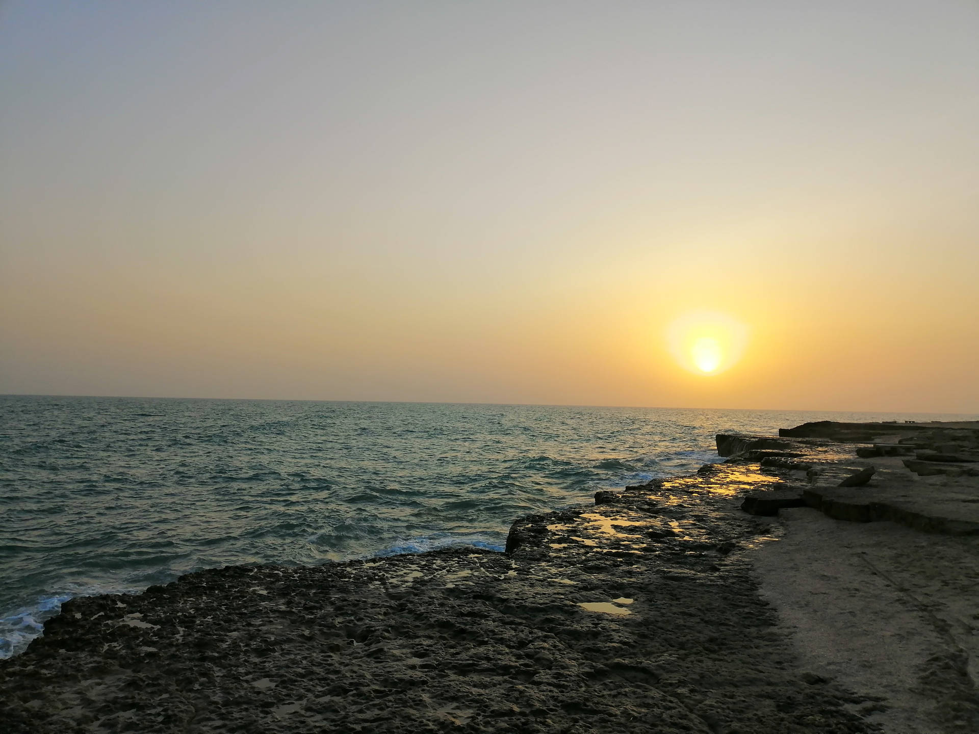 日落海洋，海浪拍打岩石海岸