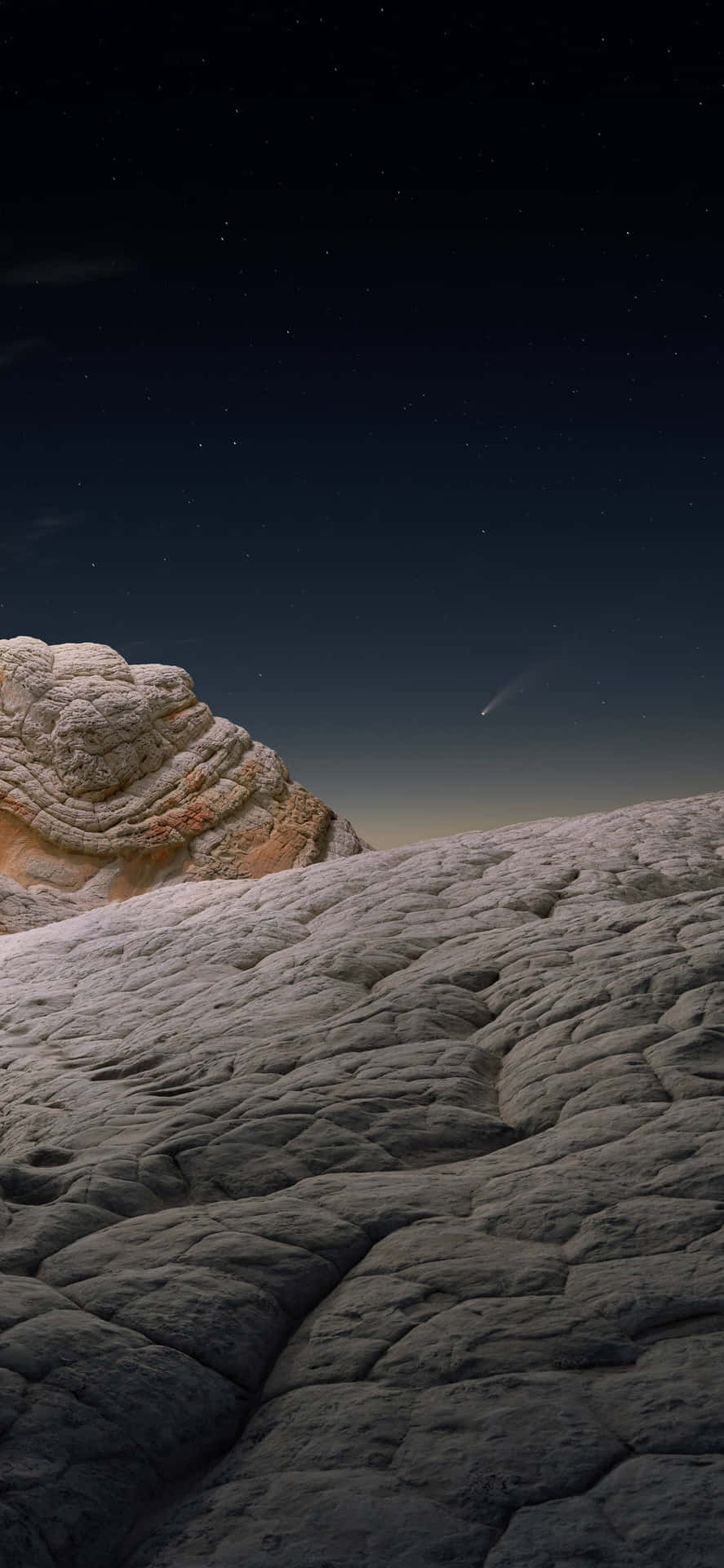 星空之夜，彗星掠過岩石沙漠景觀。