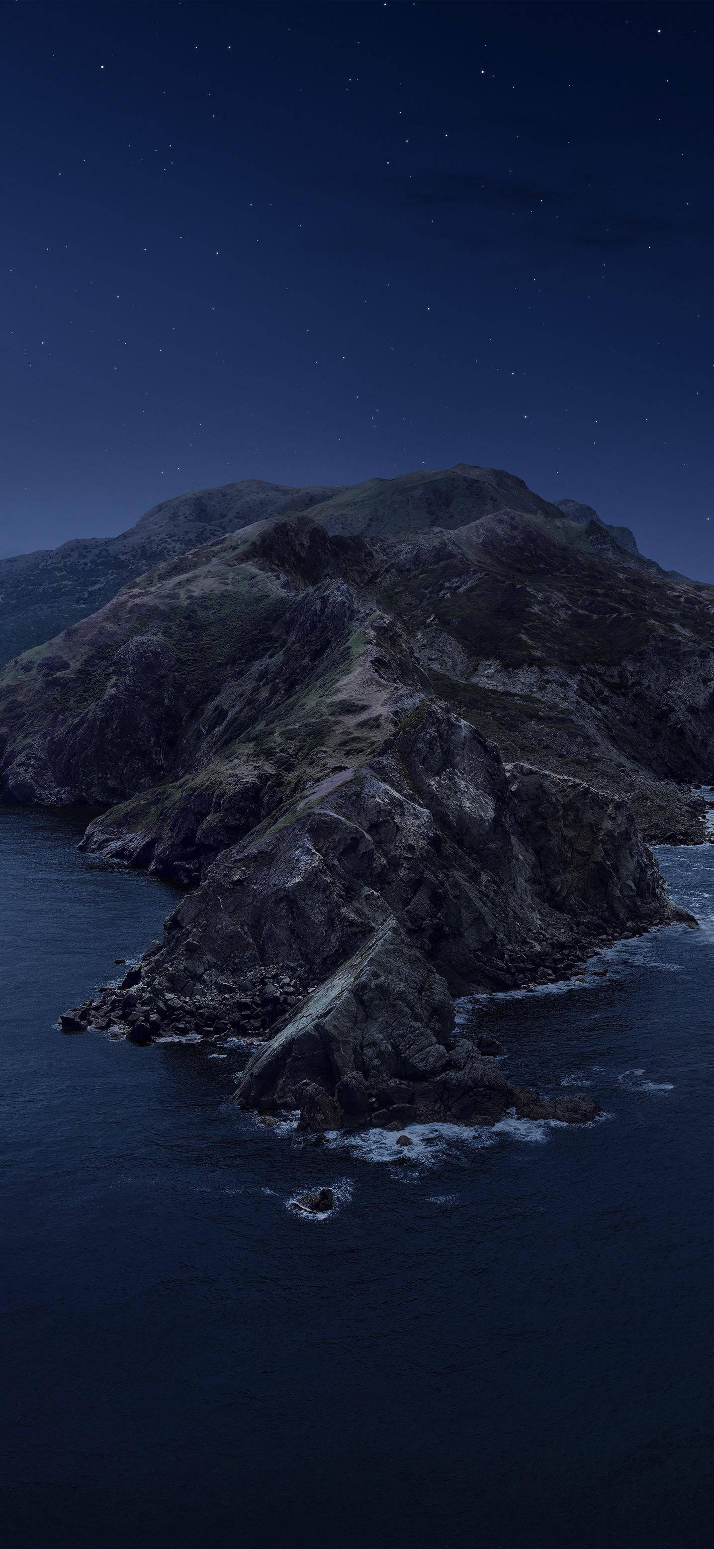 Mountain 桌布 壁紙 — 崎嶇的山崖在繁星點點的夜空下伸入黑暗的海洋，溫柔的波浪在下方拍打。