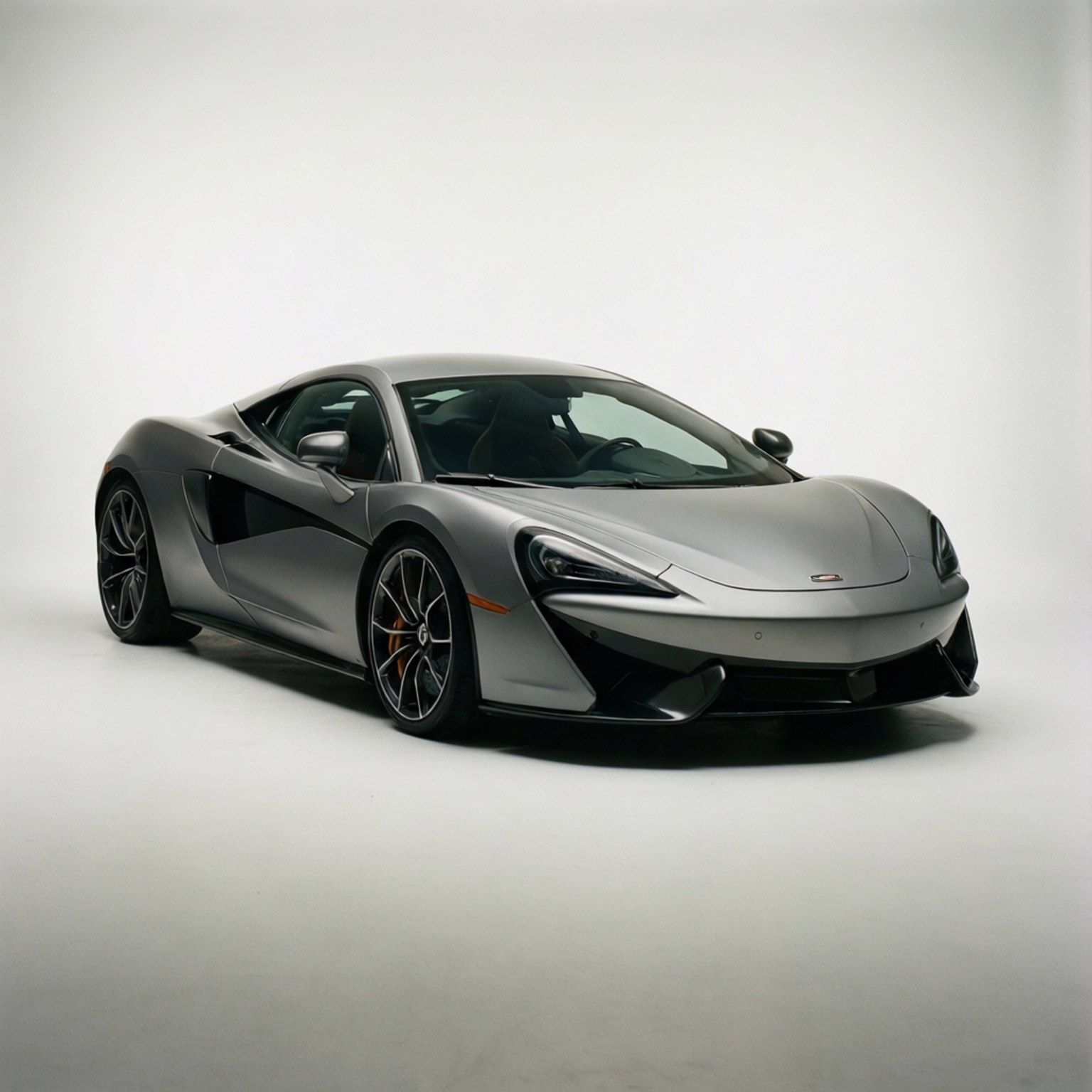 工作室優雅風 壁紙 — 一輛時尚的銀色McLaren跑車，帶有黑色飾邊和橙色制動卡鉗，在極簡的白色工作室背景下擺拍。