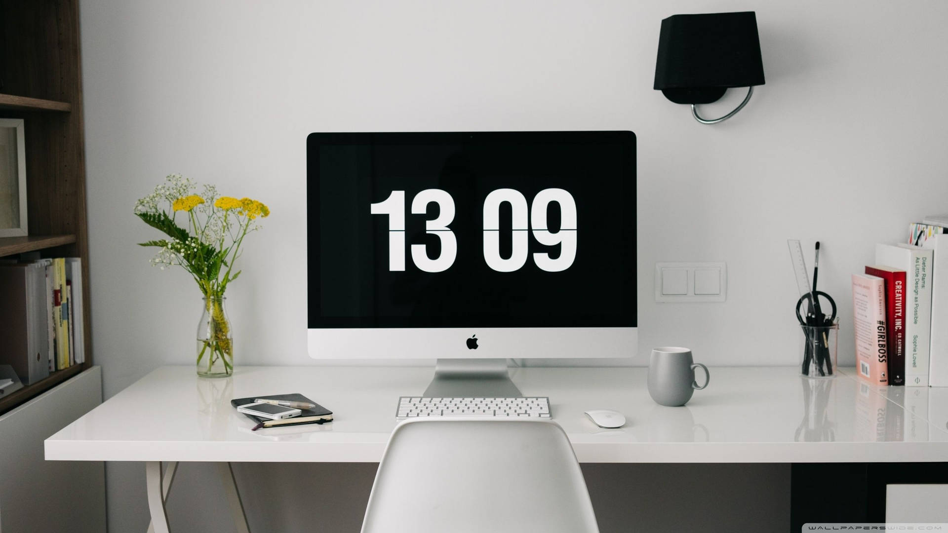 簡約家居辦公室，iMac 顯示日期，周圍環繞書籍和鮮花。