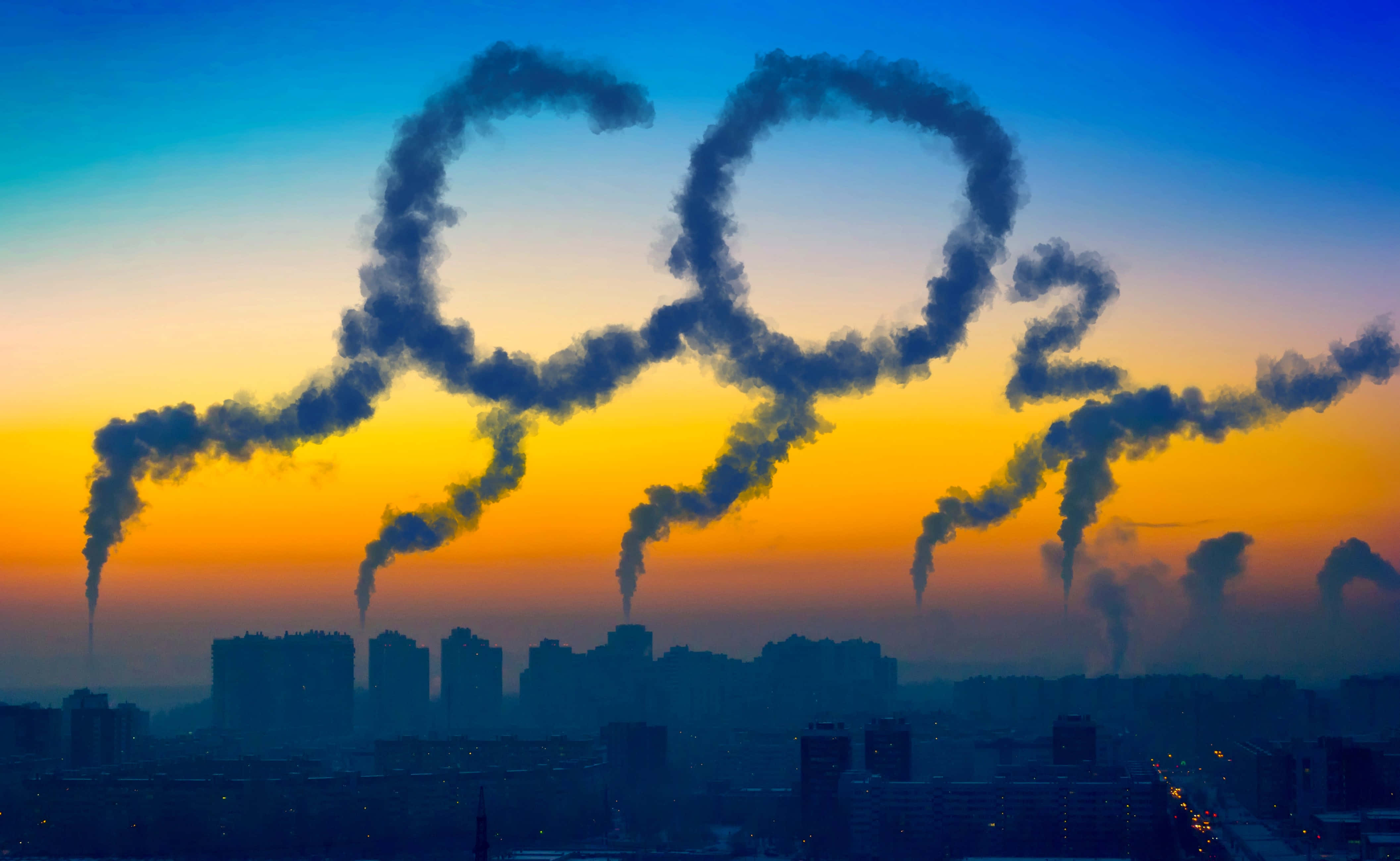 Carbon Footprint 桌布 壁紙 — 工業煙囪的煙霧在城市景觀上方的 vibrant 日落天空背景下形成一個 CO2 分子。