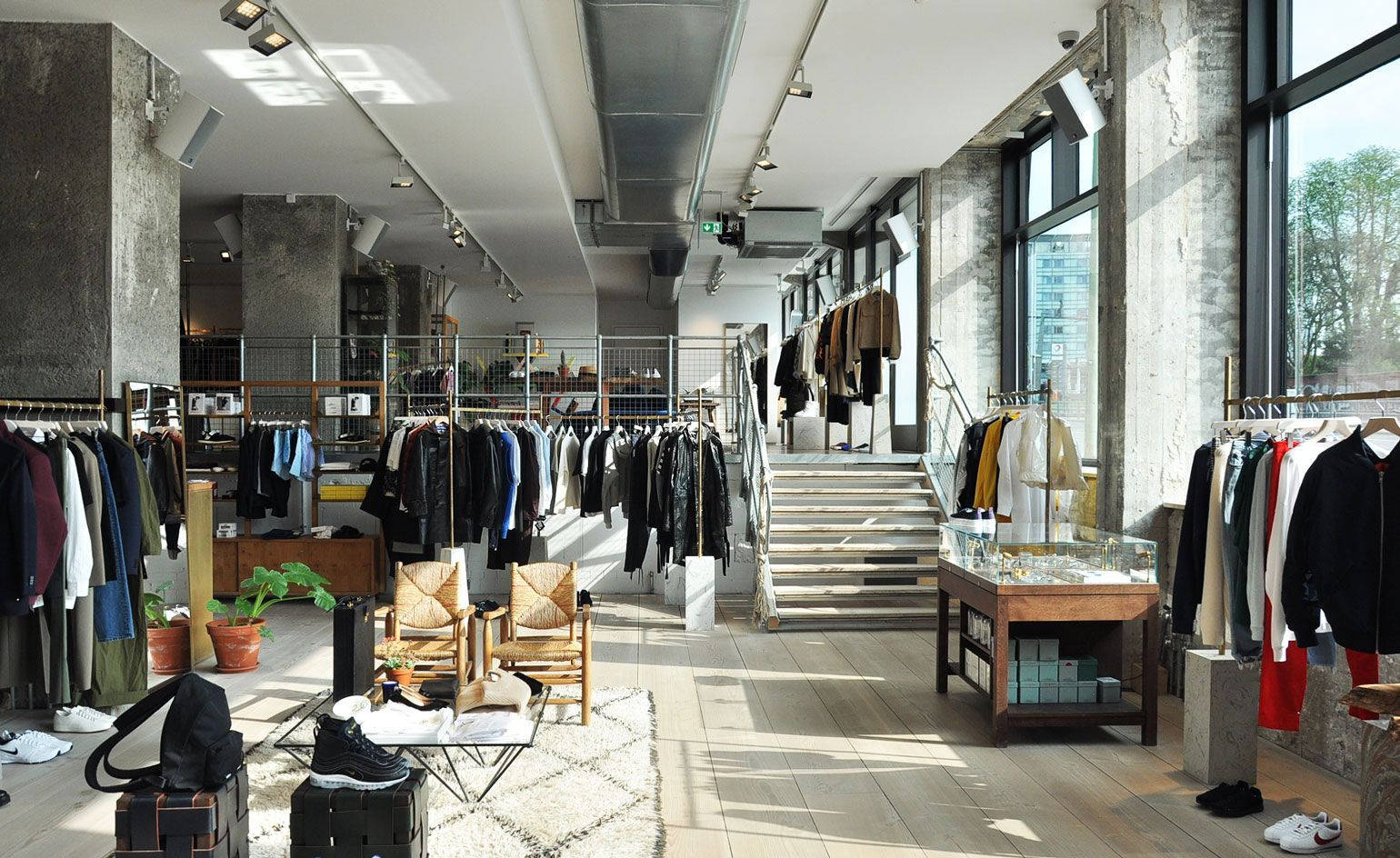 簡約服裝店，混凝土柱和木地板沐浴在陽光中。
