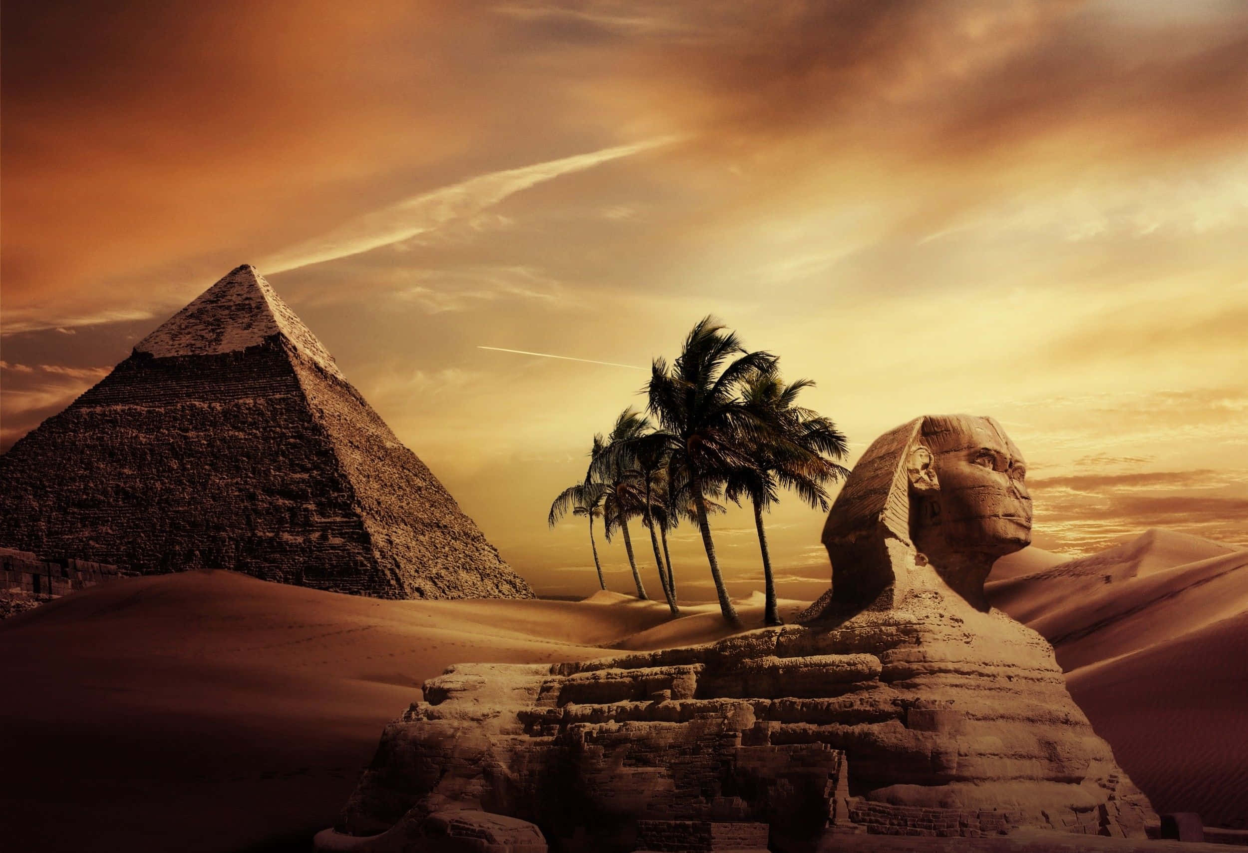 Egypt 桌布 壁紙 — 巨大的獅身人面像和金字塔從金色沙灘上聳立，在熾熱的日落天空下，棕櫚樹的剪影出現在它們之間。
