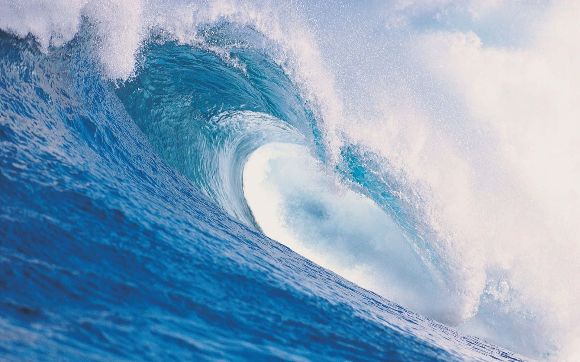 waves 桌布 壁紙 — 巨大的藍綠色海浪在明亮的天空下捲成完美的桶狀，帶有泡沫般的白色浪花。