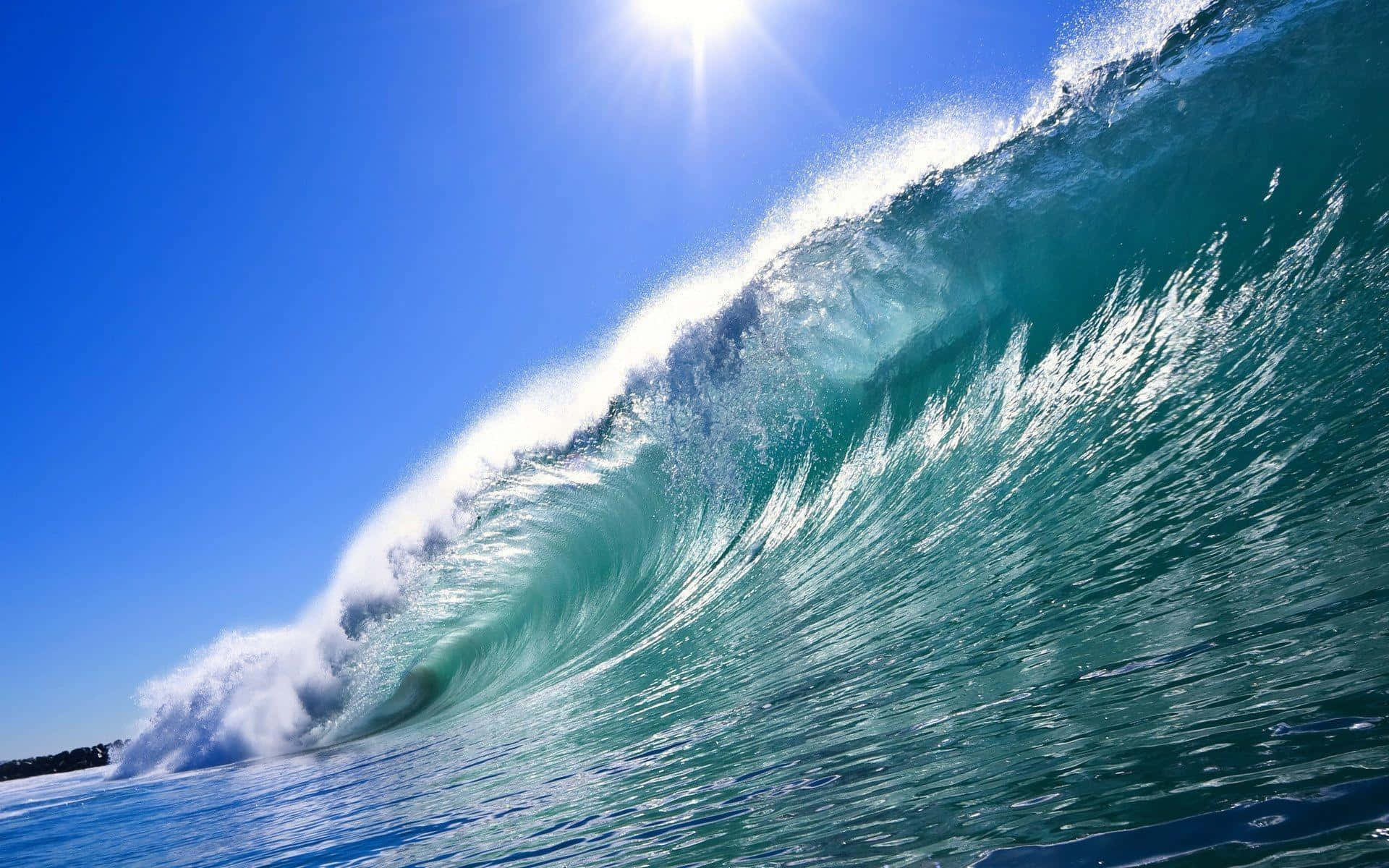 surfing 桌布 壁紙 — 巨大的藍綠色海浪在明亮的陽光下翻滾，映襯著清澈的藍天。