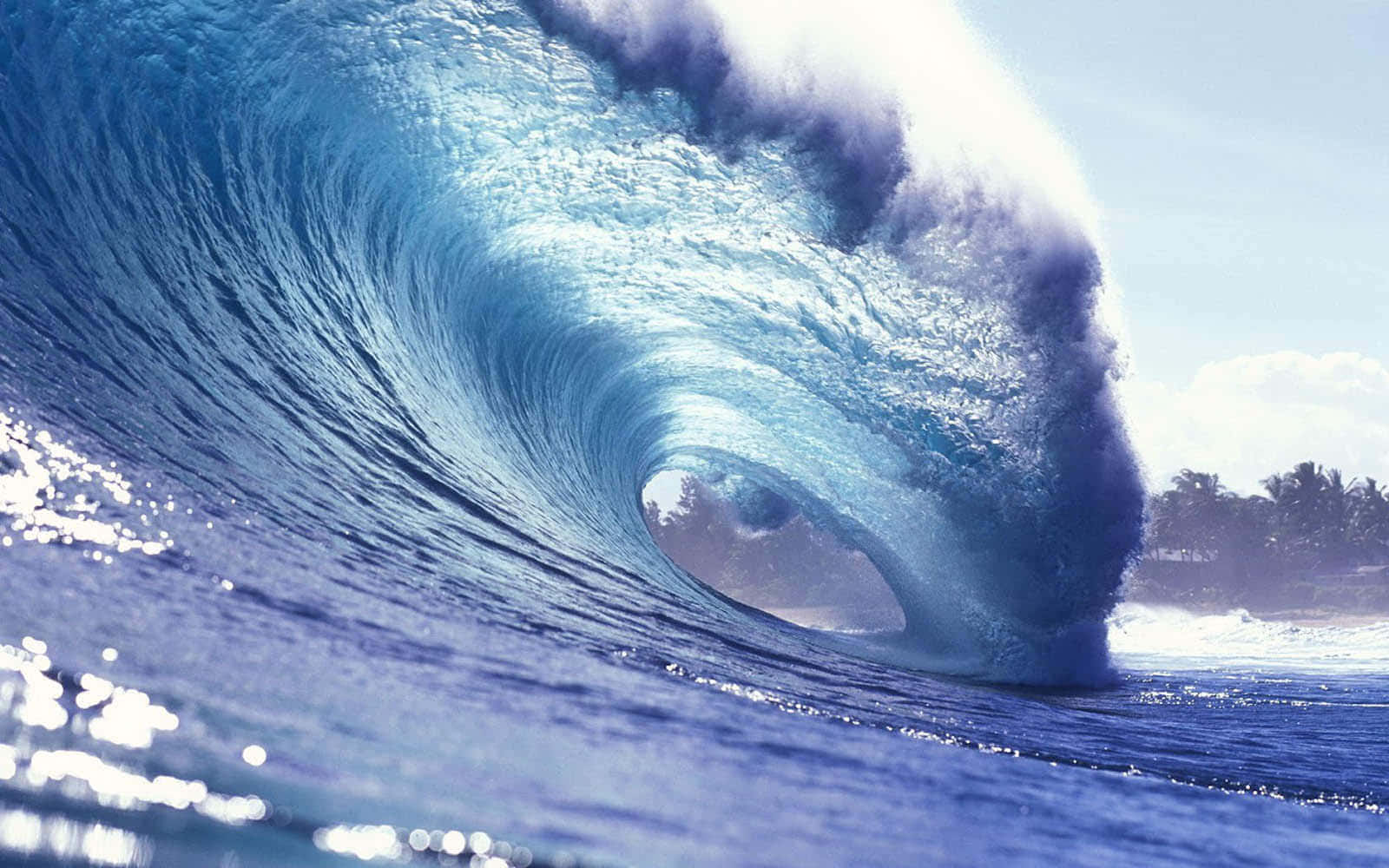 waves 桌布 壁紙 — 巨大的藍綠色海浪捲成完美的桶狀，水花四濺，陽光在水面上閃爍。