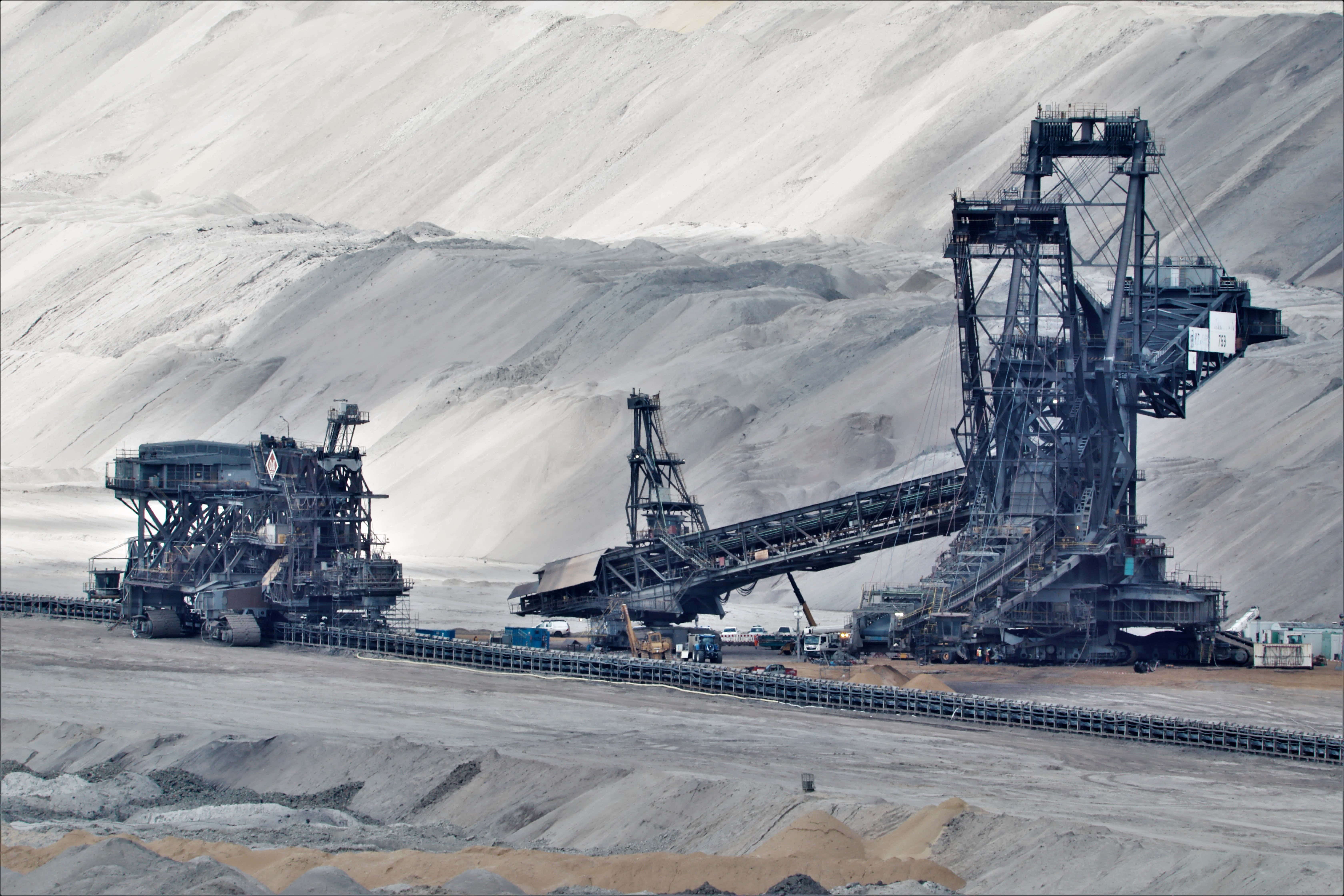 Mining 桌布 壁紙 — 巨大的露天採礦機械在陰天籠罩下，主宰著廣闊的灰色採石場景觀。