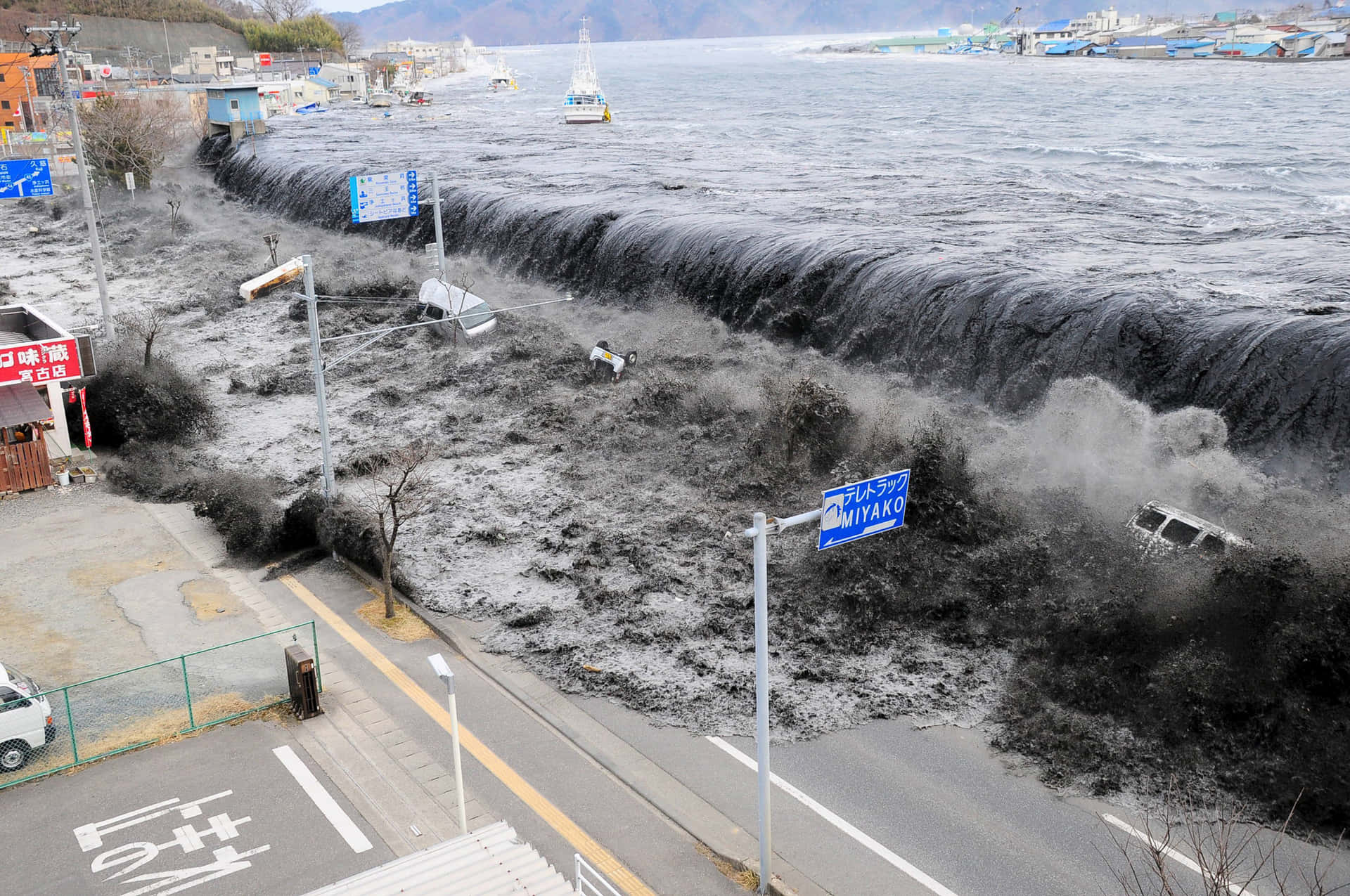 海嘯淹沒日本沿海城鎮，汽車和建築物被淹沒。