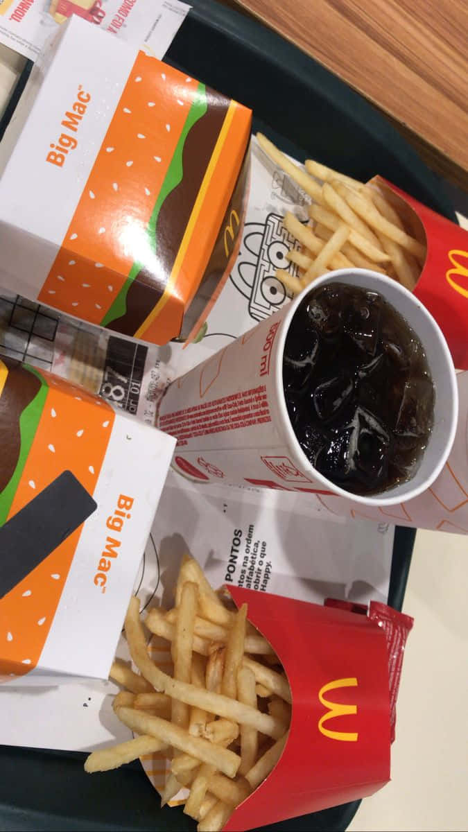巨無霸與薯條麥當勞美食圖 壁紙 — 從上方俯瞰一個麥當勞餐點，黑色托盤上有兩個巨無霸盒子、薯條和一杯冰可樂。