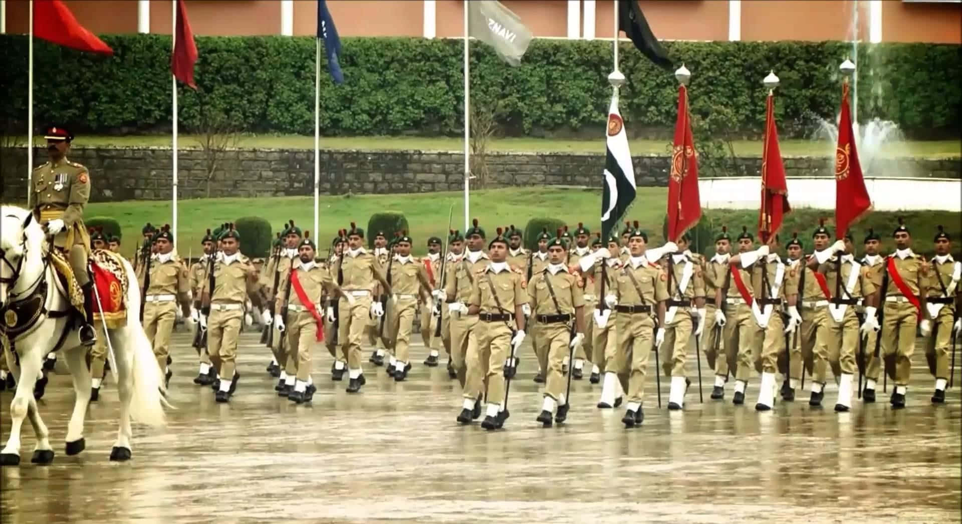 在雨中軍事閱兵中，身穿制服的士兵與旗幟和一名騎兵軍官一起列隊行進。