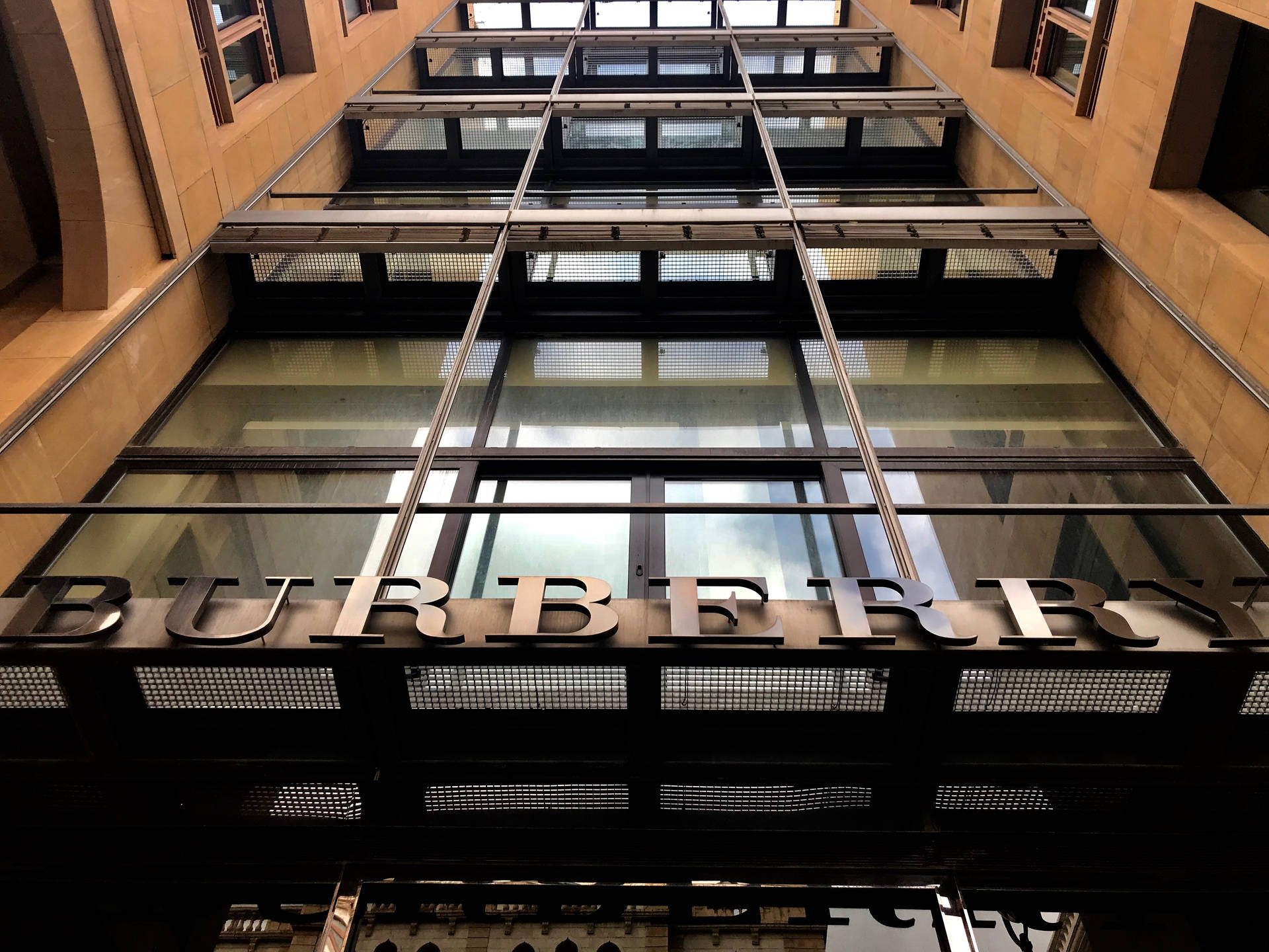 現代城市環境中帶有玻璃面板和金屬標誌的 Burberry 商店入口。