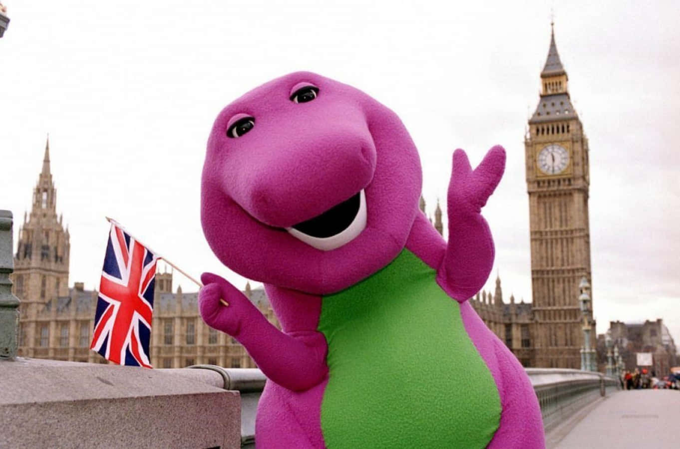 紫色 Barney 吉祥物在倫敦大笨鐘附近揮舞英國國旗。