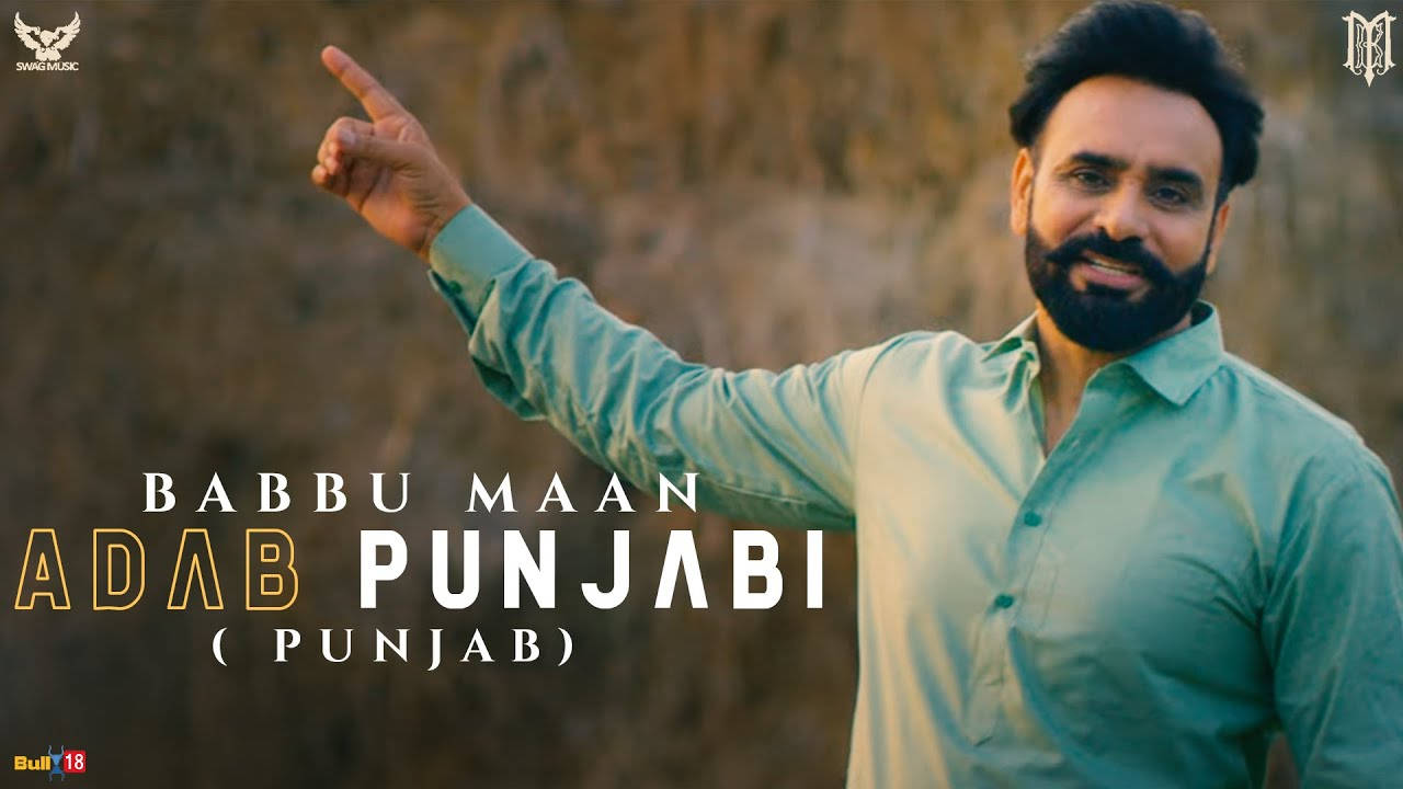 身穿青綠色襯衫的男子指向文字 Babbu Maan Adab Punjabi