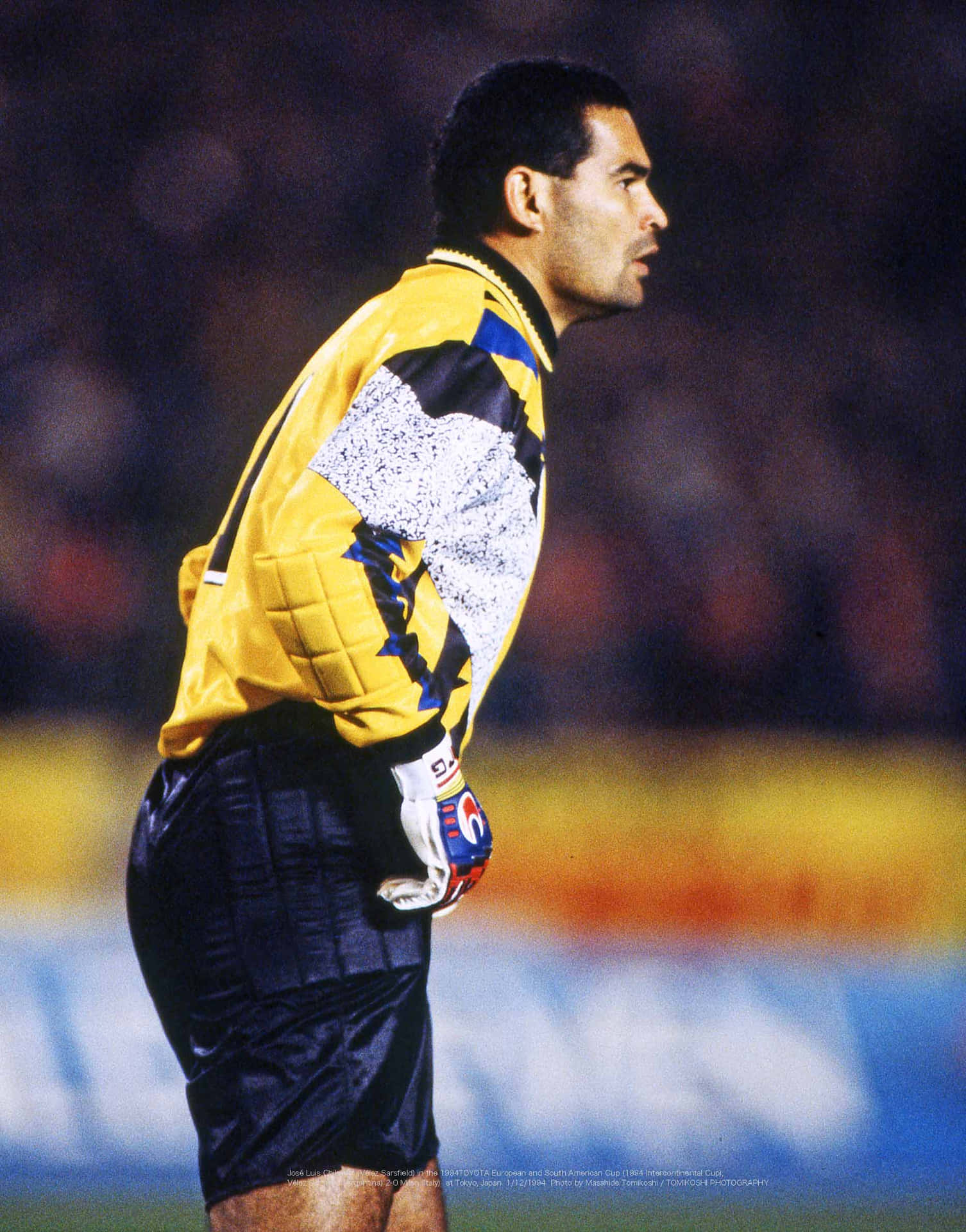 巴拉圭足球員José Luis Chilavert於1994年洲際杯 壁紙 — 一位身穿黃黑球衣的足球守門員在球場燈光下專注地站在場上。
