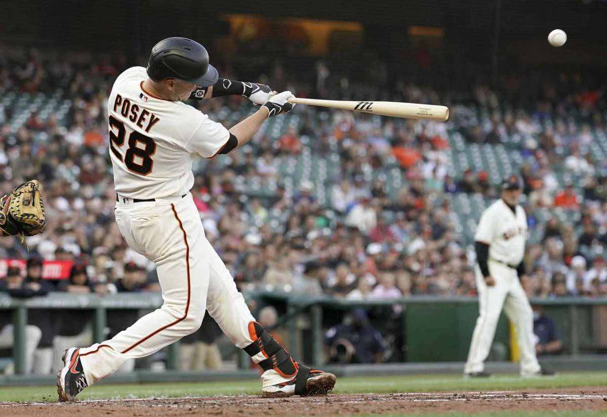 巴斯特·波西全壘打 壁紙 — 棒球手Posey 28號在夜間比賽中揮棒擊球，背景為體育場內的觀眾。