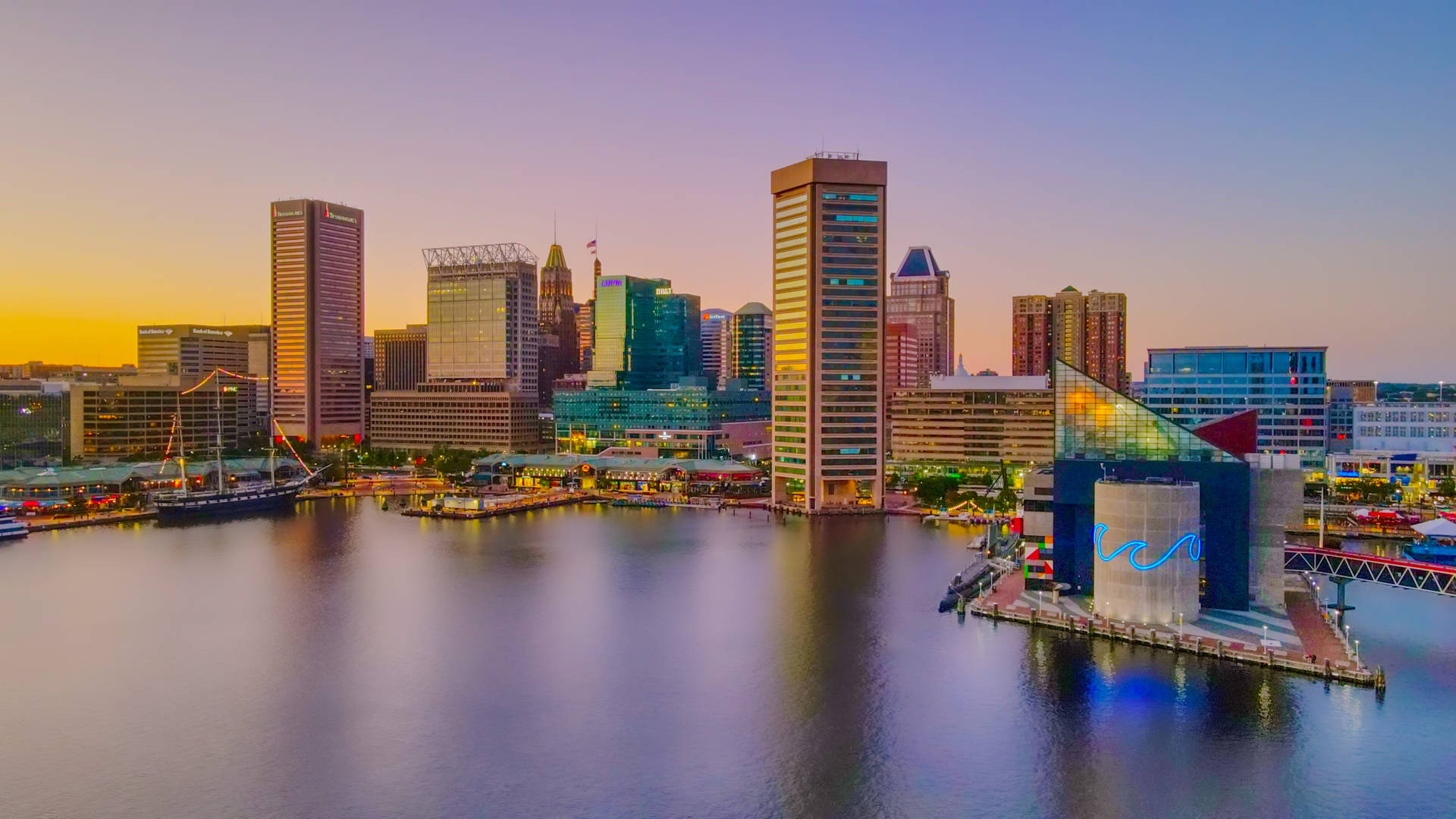 夕陽下的城市天際線，水面倒影和現代建築。