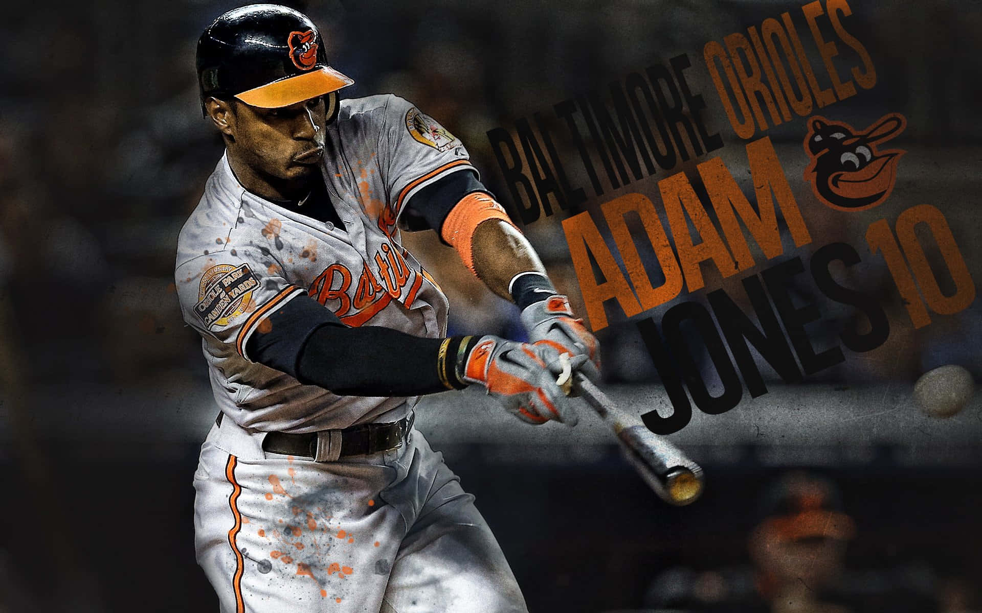 MLB Baseball League 桌布 壁紙 — 巴爾的摩金鶯隊棒球選手Adam Jones穿著制服，在揮棒中途擊球，背景有泥土飛濺和球隊標誌。