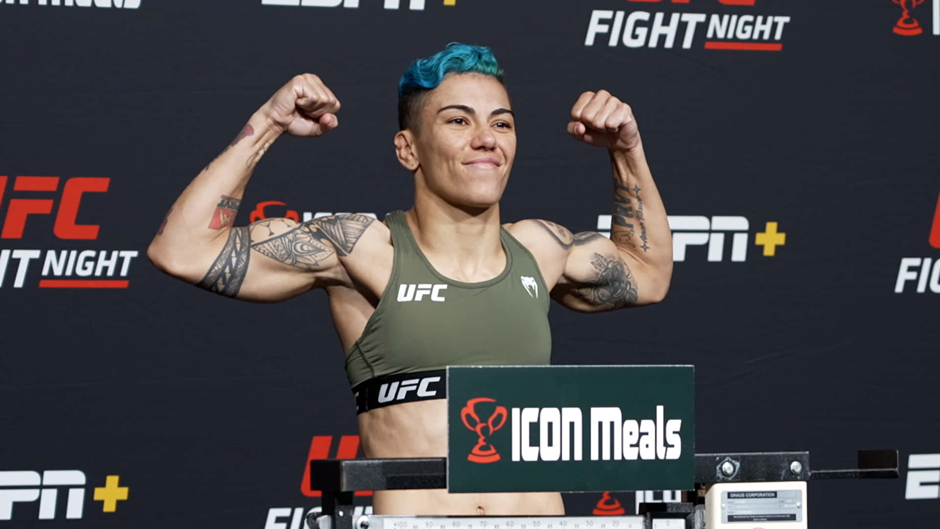 UFC拳手在稱重活動中展示手臂，藍髮和紋身