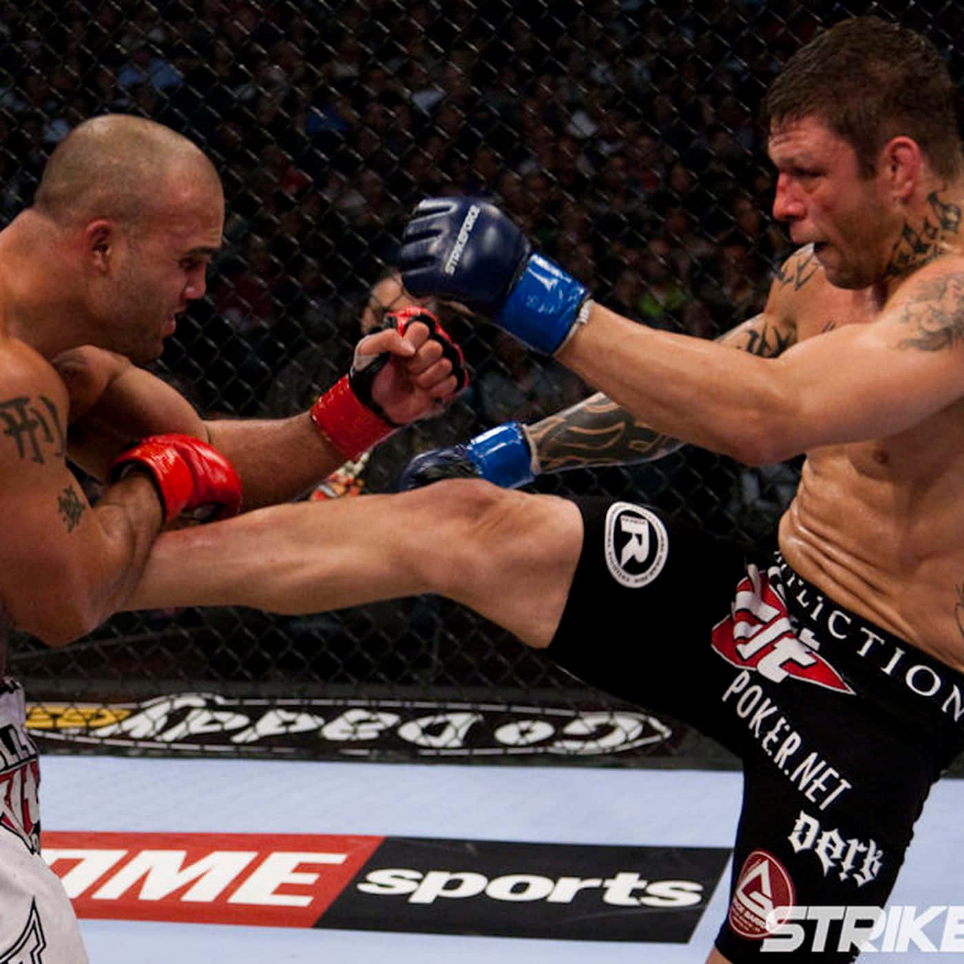 巴西UFC選手Renato Sobral與Dan Henderson於Strikeforce賽事對決 壁紙 — 兩名MMA拳手在激烈的鐵籠賽中交鋒，一人使出高踢，另一人則進行阻擋。