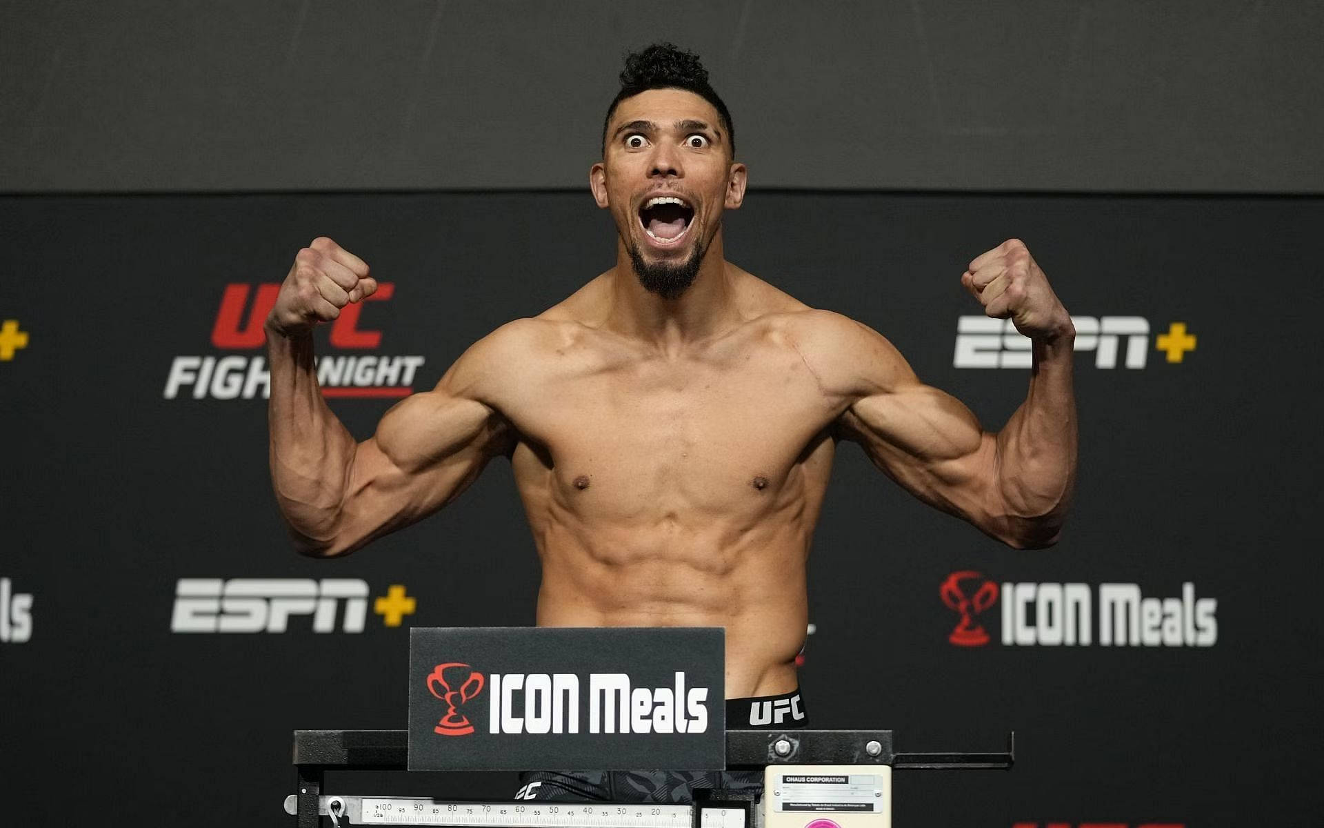 UFC戰士在稱重時舉起拳頭慶祝勝利。