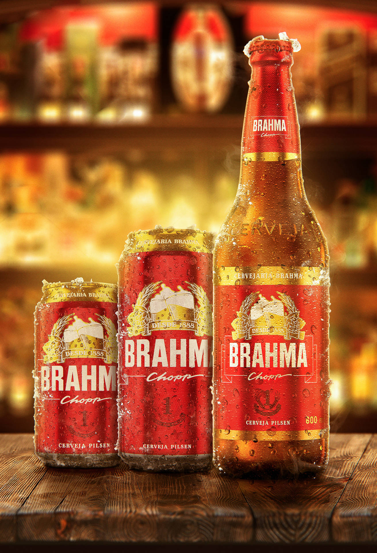 三罐冰凍的 Brahma 啤酒罐和一瓶啤酒放在溫暖燈光的酒吧木吧台上。