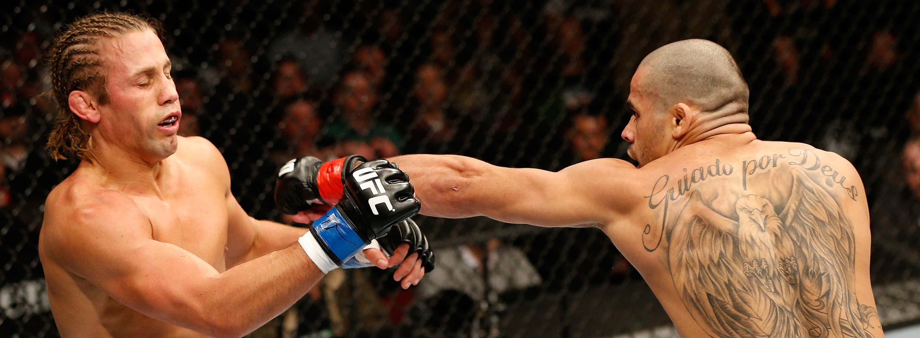 巴西綜合格鬥選手雷南·巴羅出拳 壁紙 — 兩名MMA拳手在激烈的鐵籠賽中交鋒，一人打出強力一拳，另一人以手套和可見的紋身進行阻擋。