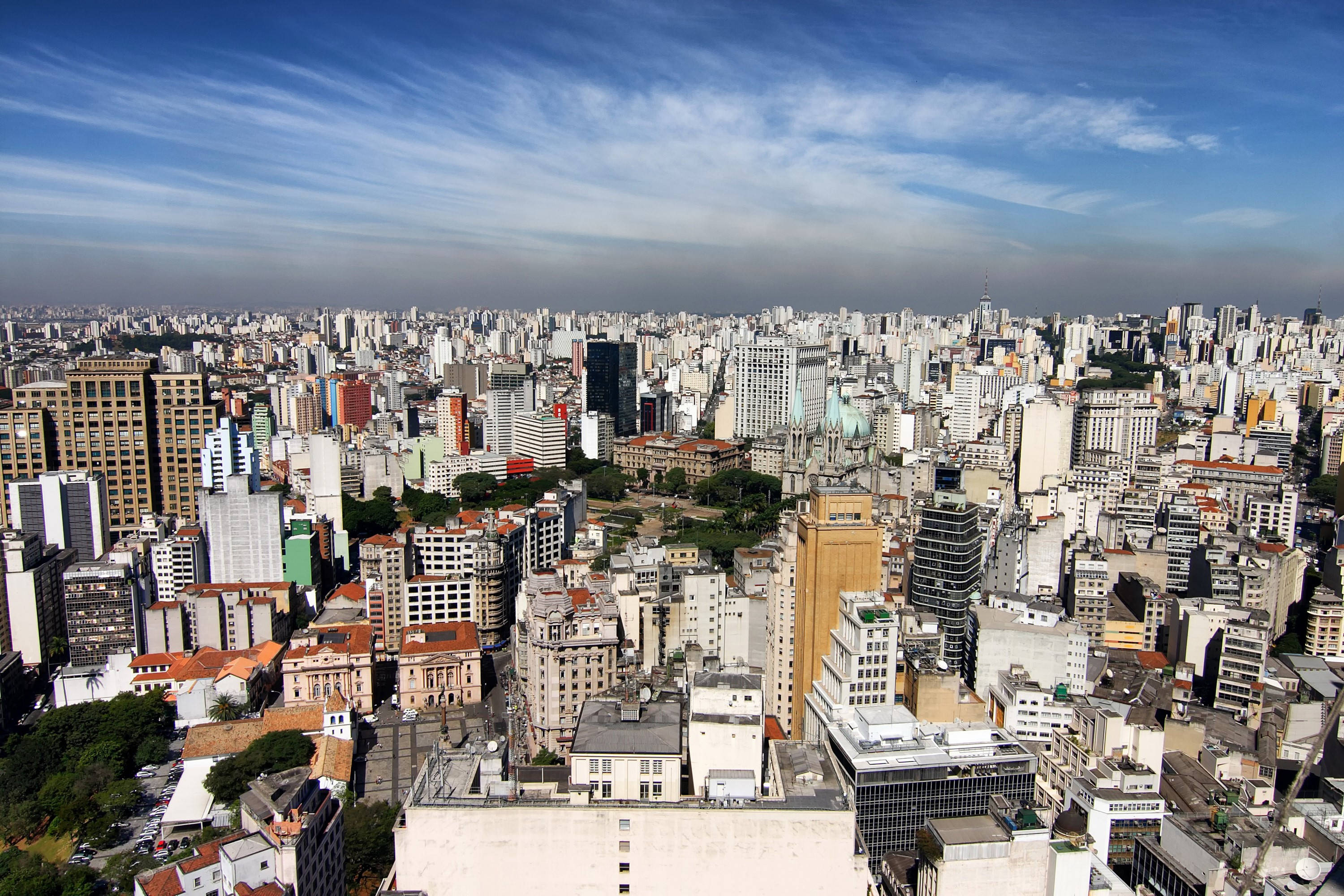 巴西聖保羅城市風景日間 壁紙 — 廣闊城市景觀的鳥瞰圖，天空湛藍明亮，雲朵輕柔。