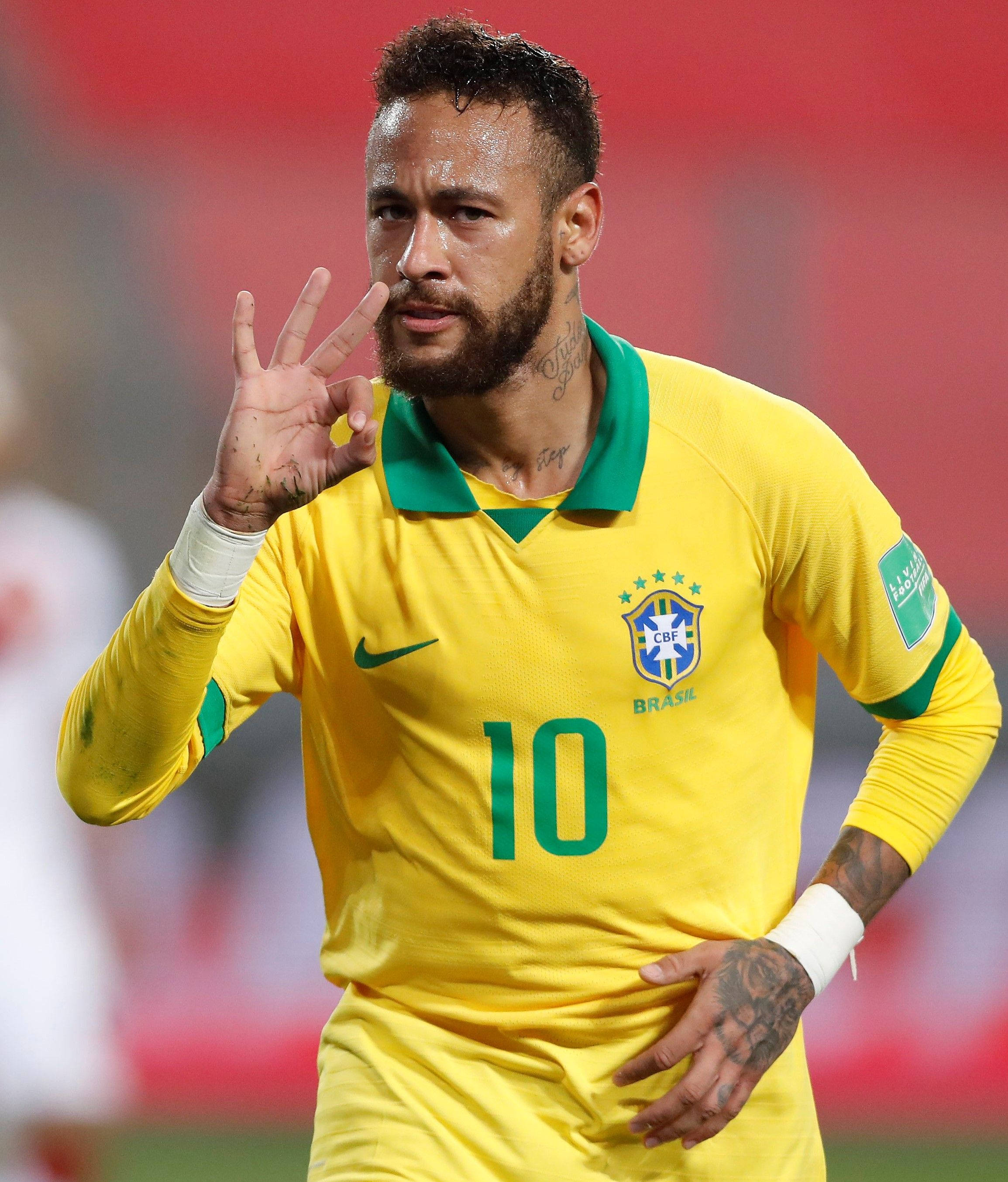 足球 桌布 壁紙 — 巴西足球巨星尼馬（Neymar Jr.）身穿黃色10號球衣在球場上做出和平手勢。